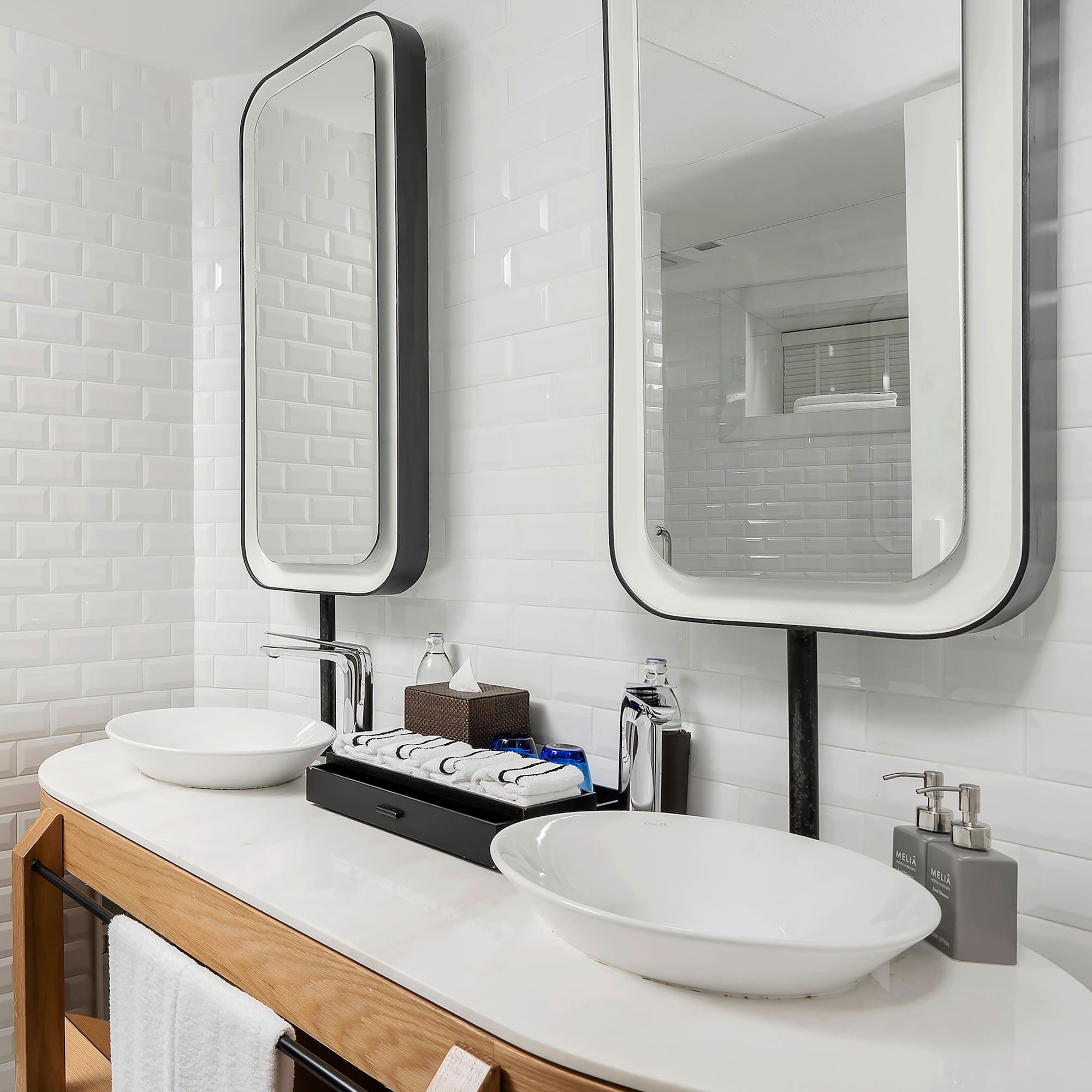a bathroom with a double sink and two mirrors