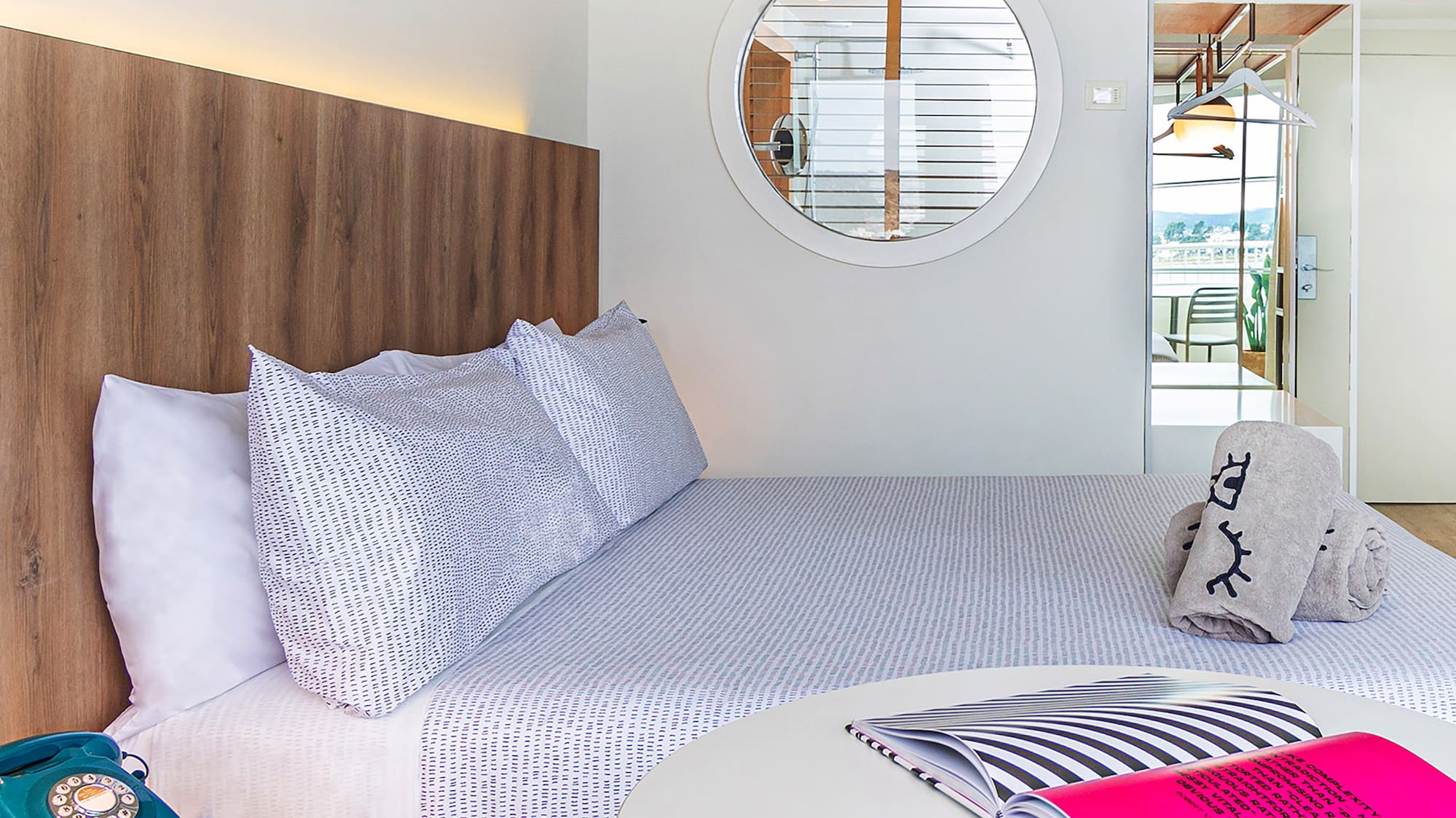 a bed with a round table and a round mirror