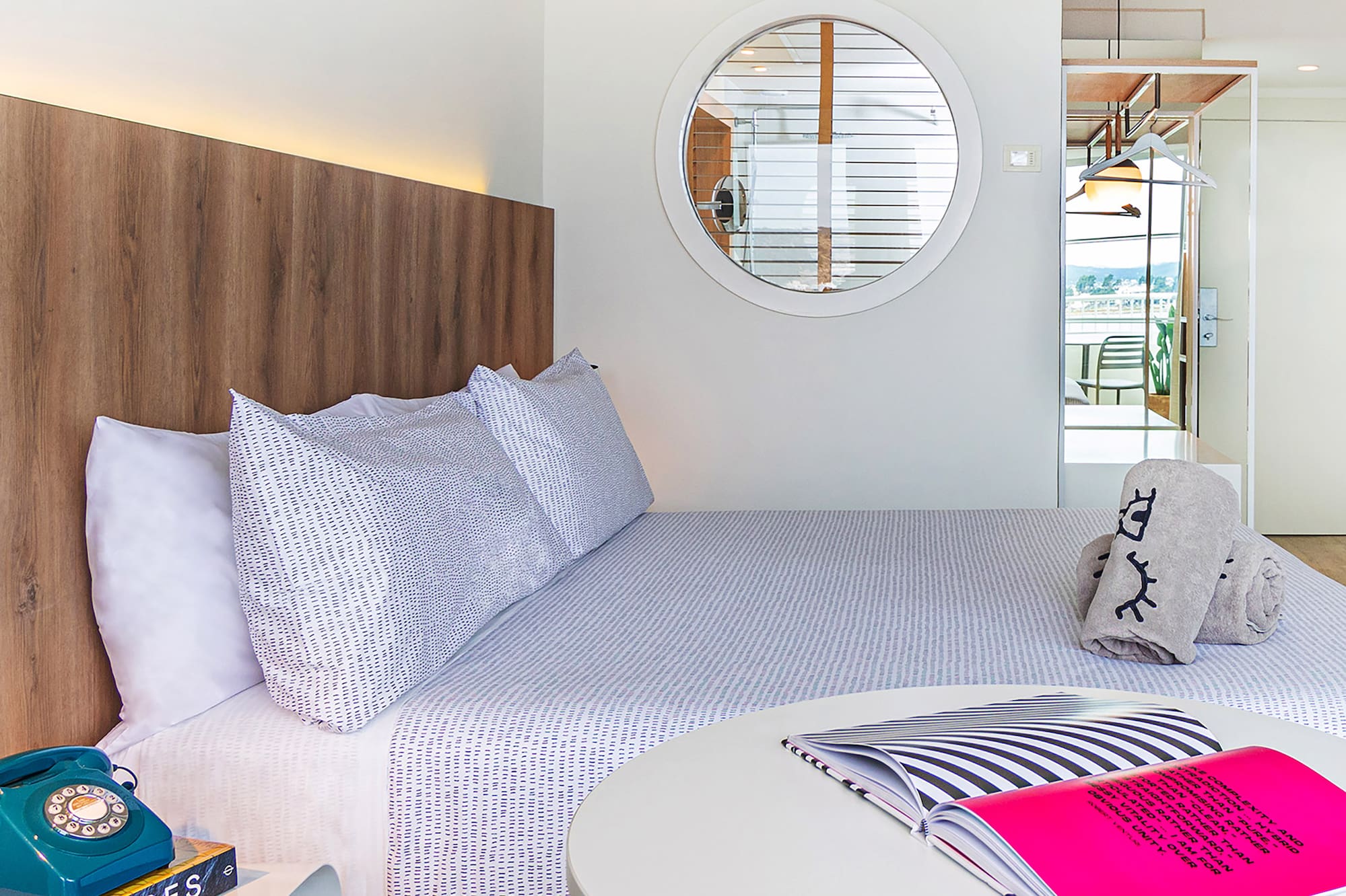 a bed with a round table and a round mirror