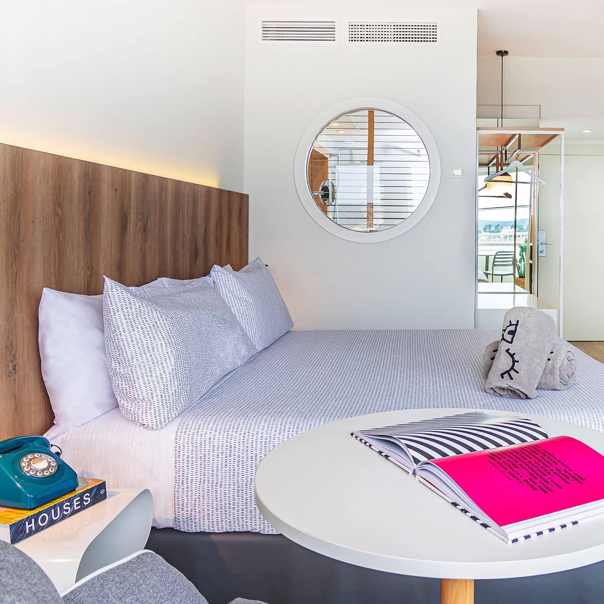 a bed with a round table and a round mirror