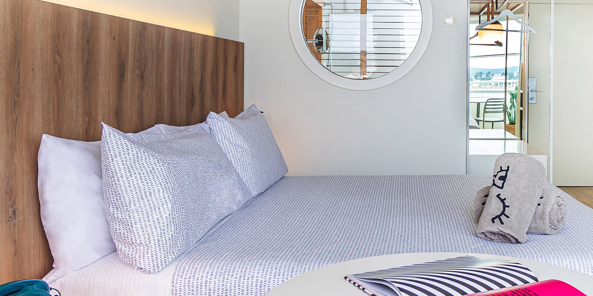 a bed with a round table and a round mirror