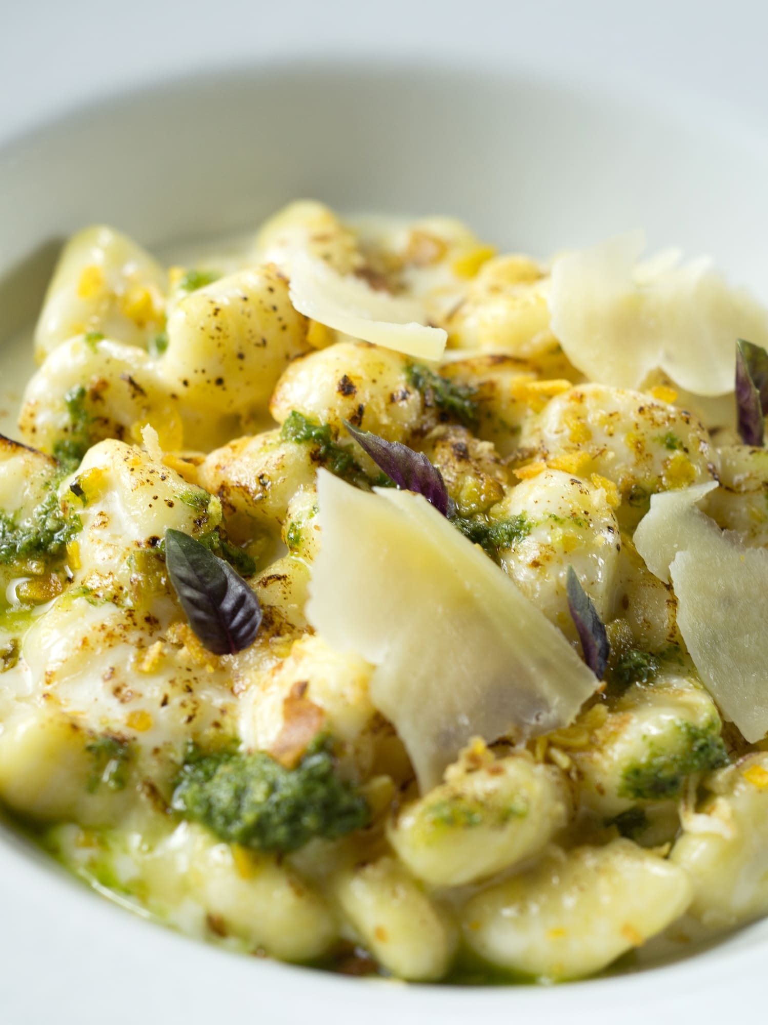 a bowl of food with cheese and herbs