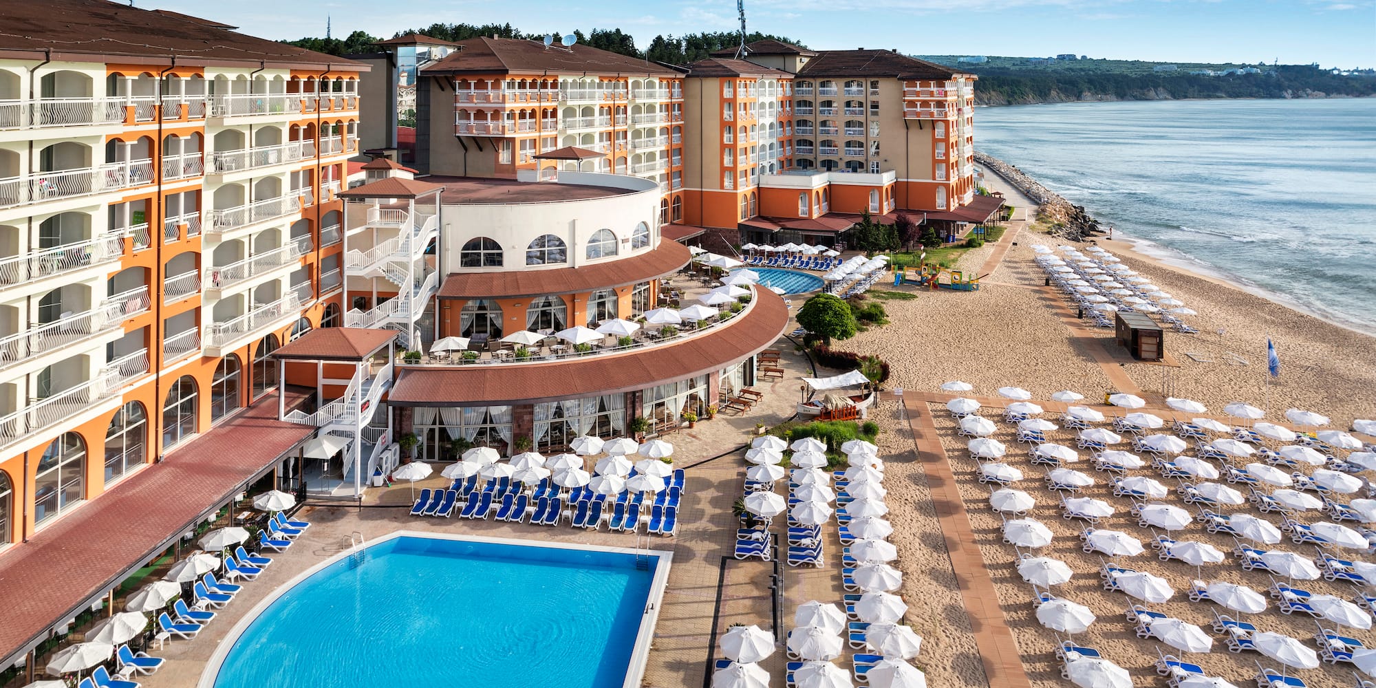 a swimming pool and beach chairs by a beach