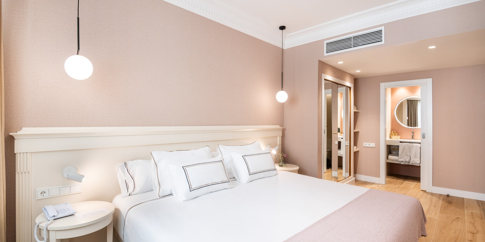 a bed with white pillows and a lamp