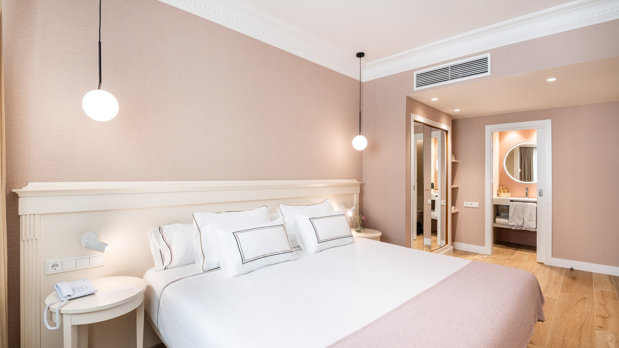 a bed with white pillows and a lamp