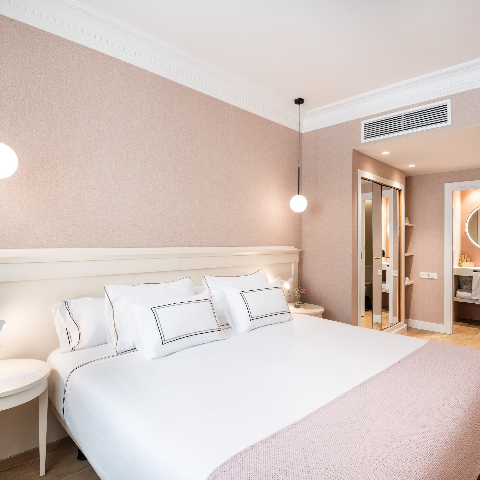 a bed with white pillows and a lamp