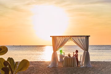 a couple sitting at a table on a beach