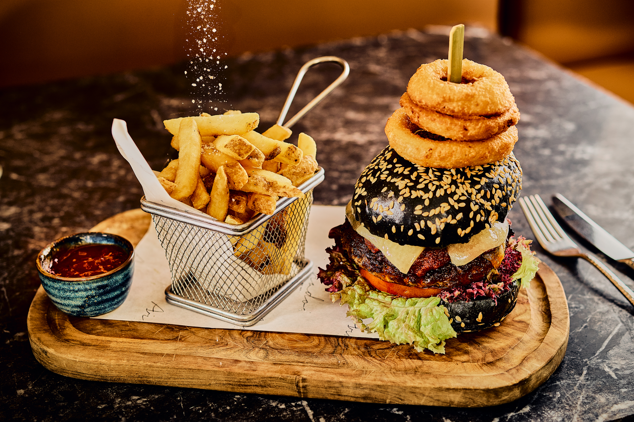 a burger and fries on a wooden board