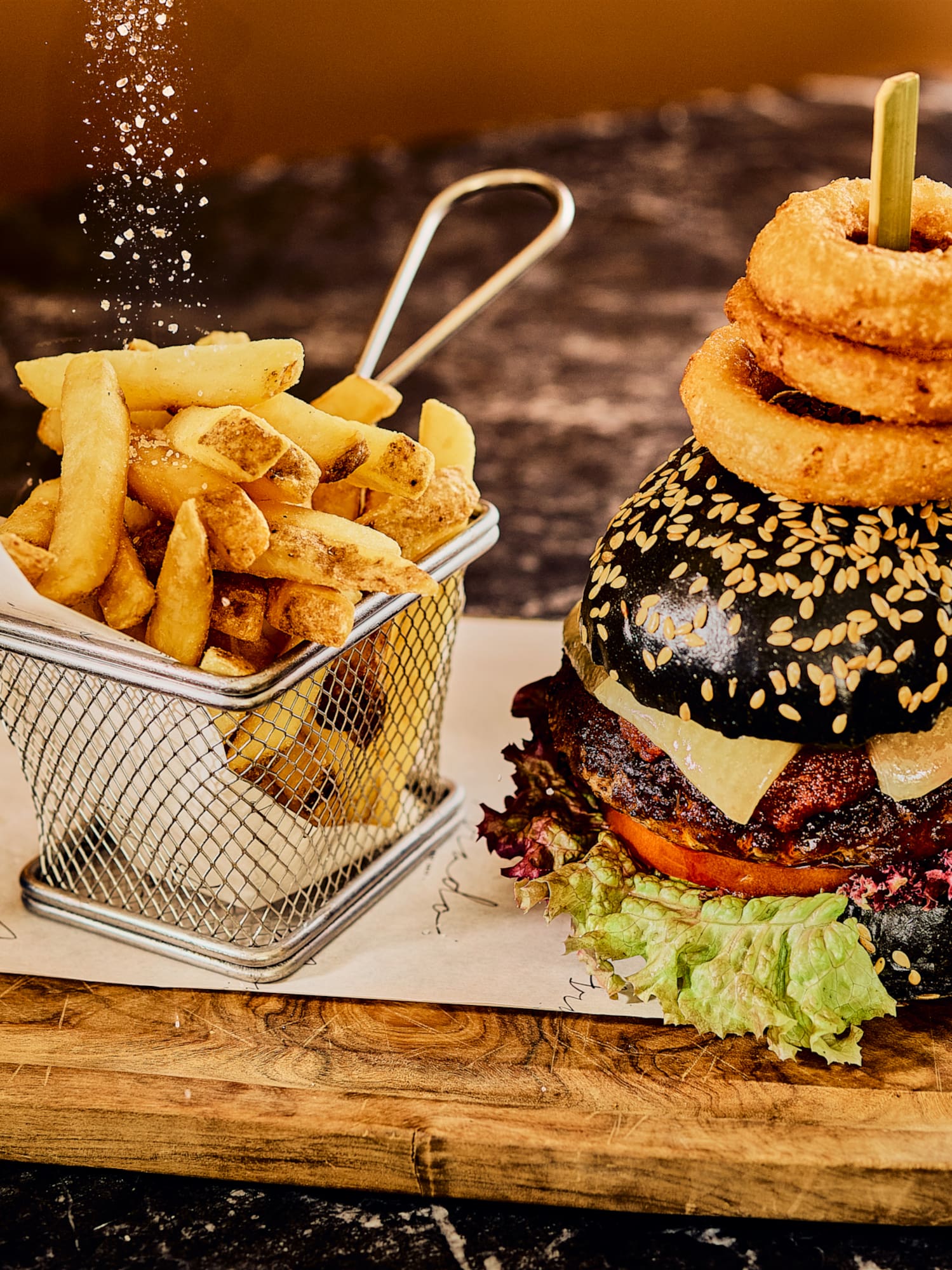 a burger and fries on a wooden board