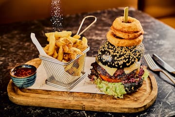 a burger and fries on a wooden board