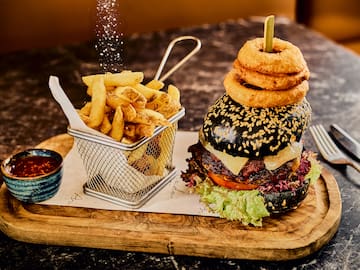 a burger and fries on a wooden board