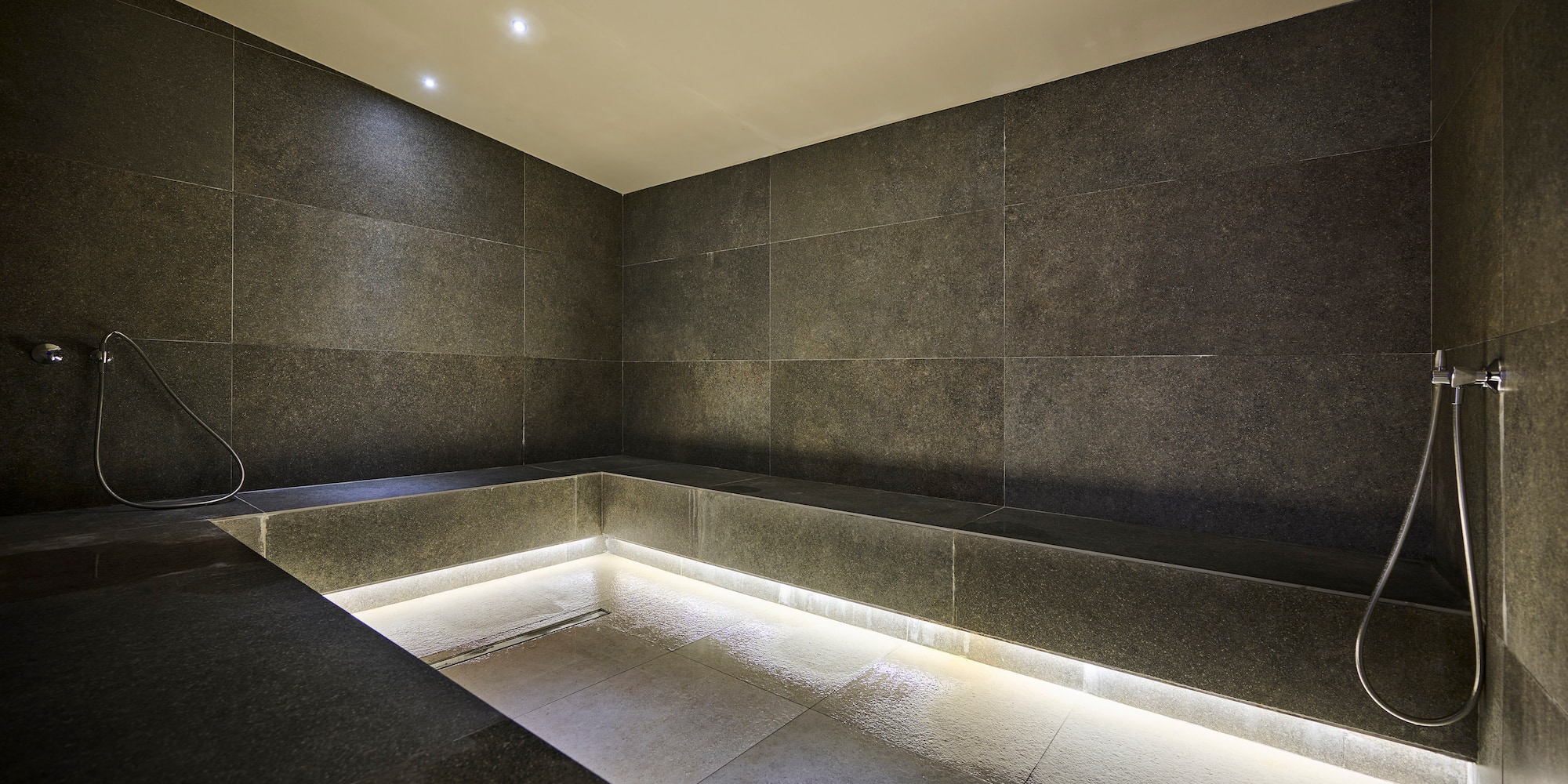 a room with a stone wall and a bench