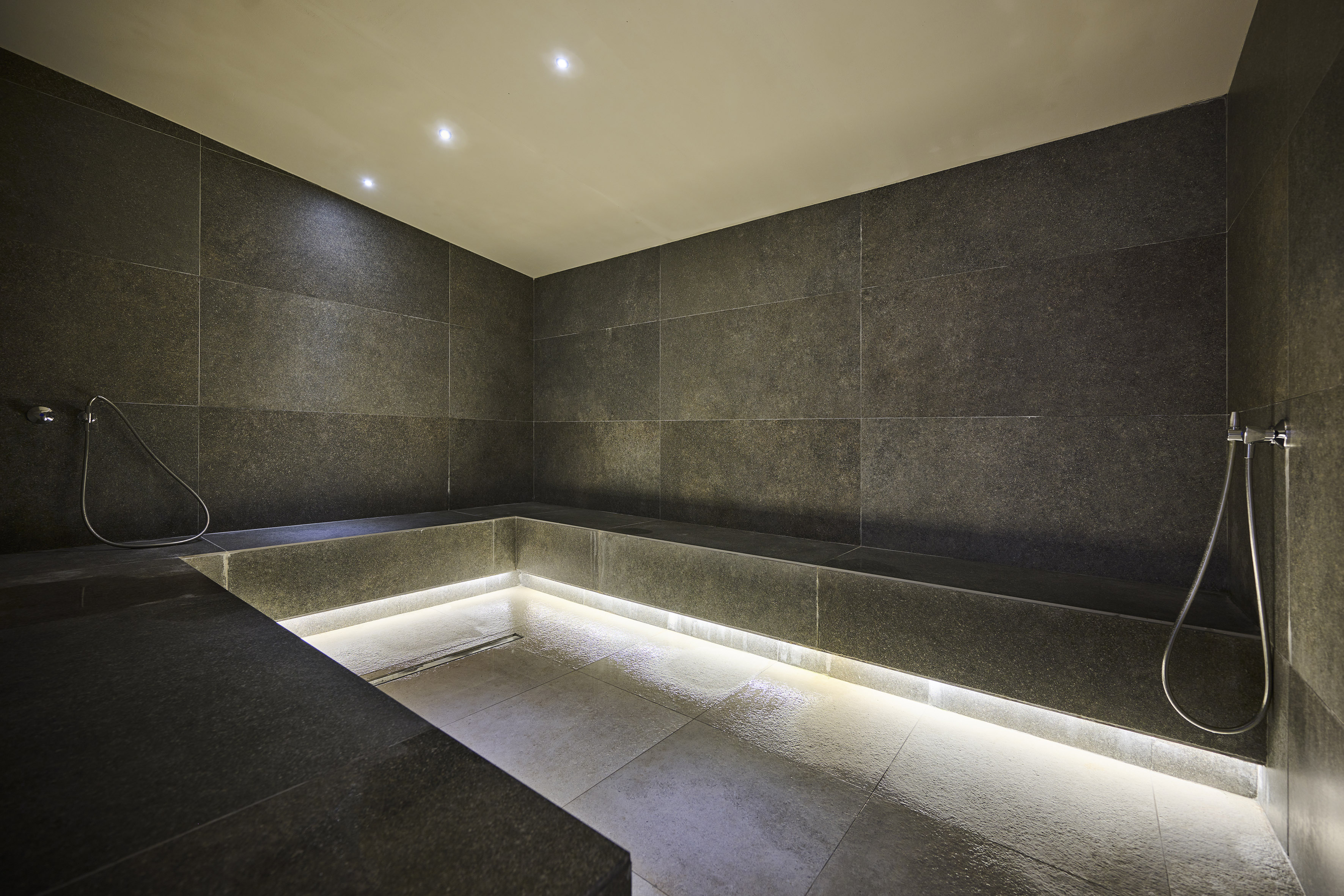 a room with a stone wall and a bench