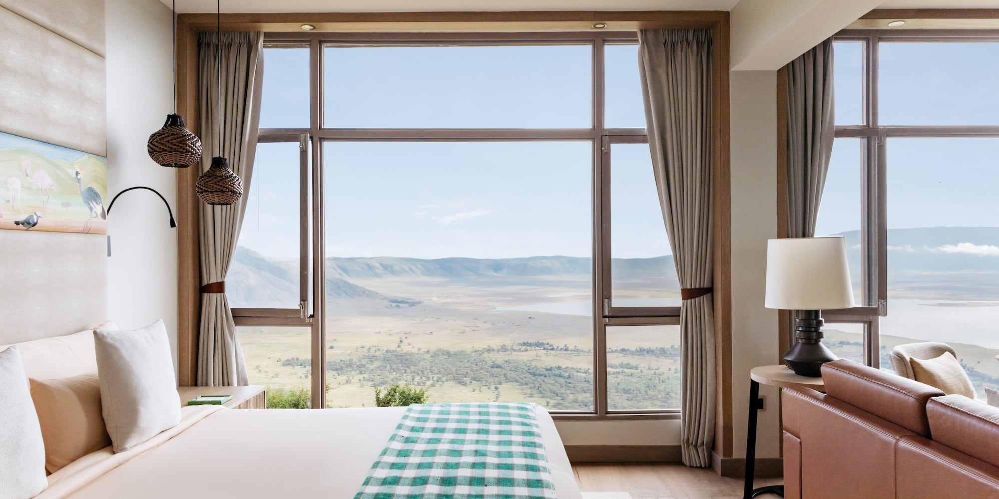 a bedroom with a large window overlooking a valley