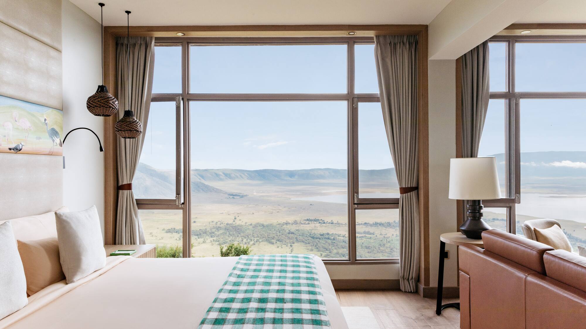 a bedroom with a large window overlooking a valley