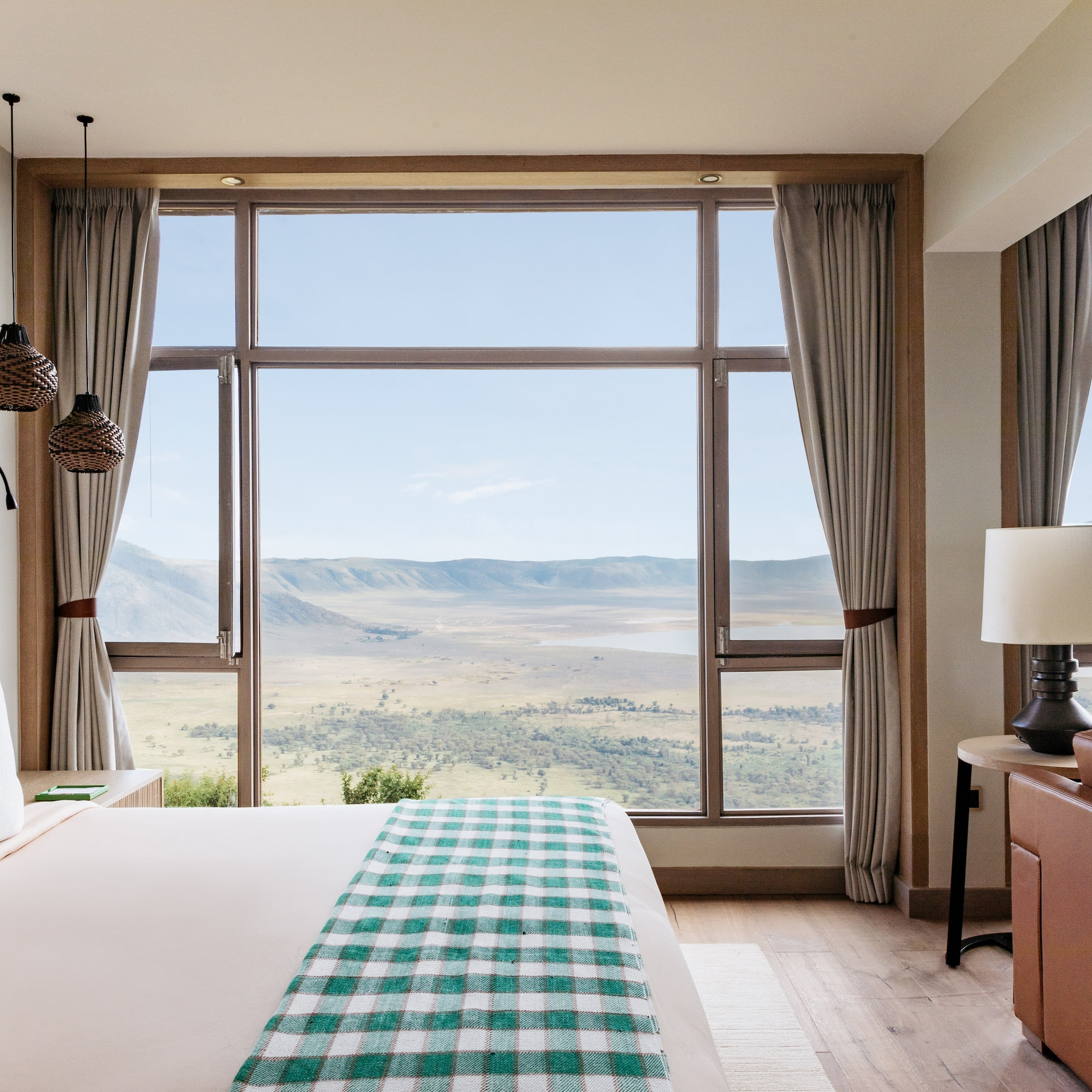 a bedroom with a large window overlooking a valley