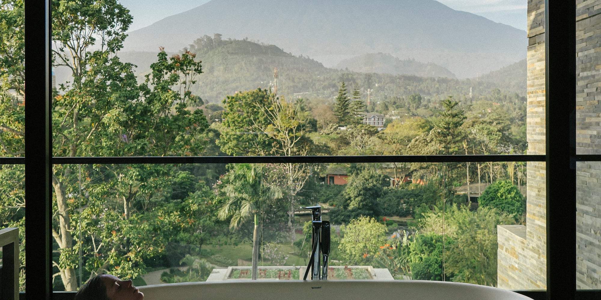 a woman in a bathtub with a view of a mountain in the background