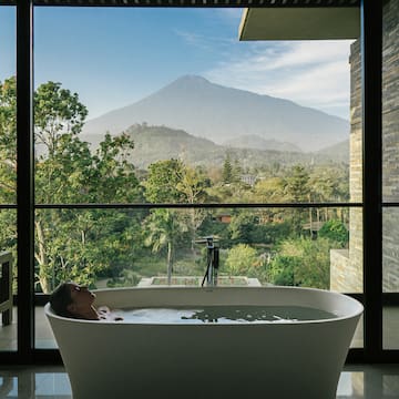 a woman in a bathtub with a view of a mountain in the background