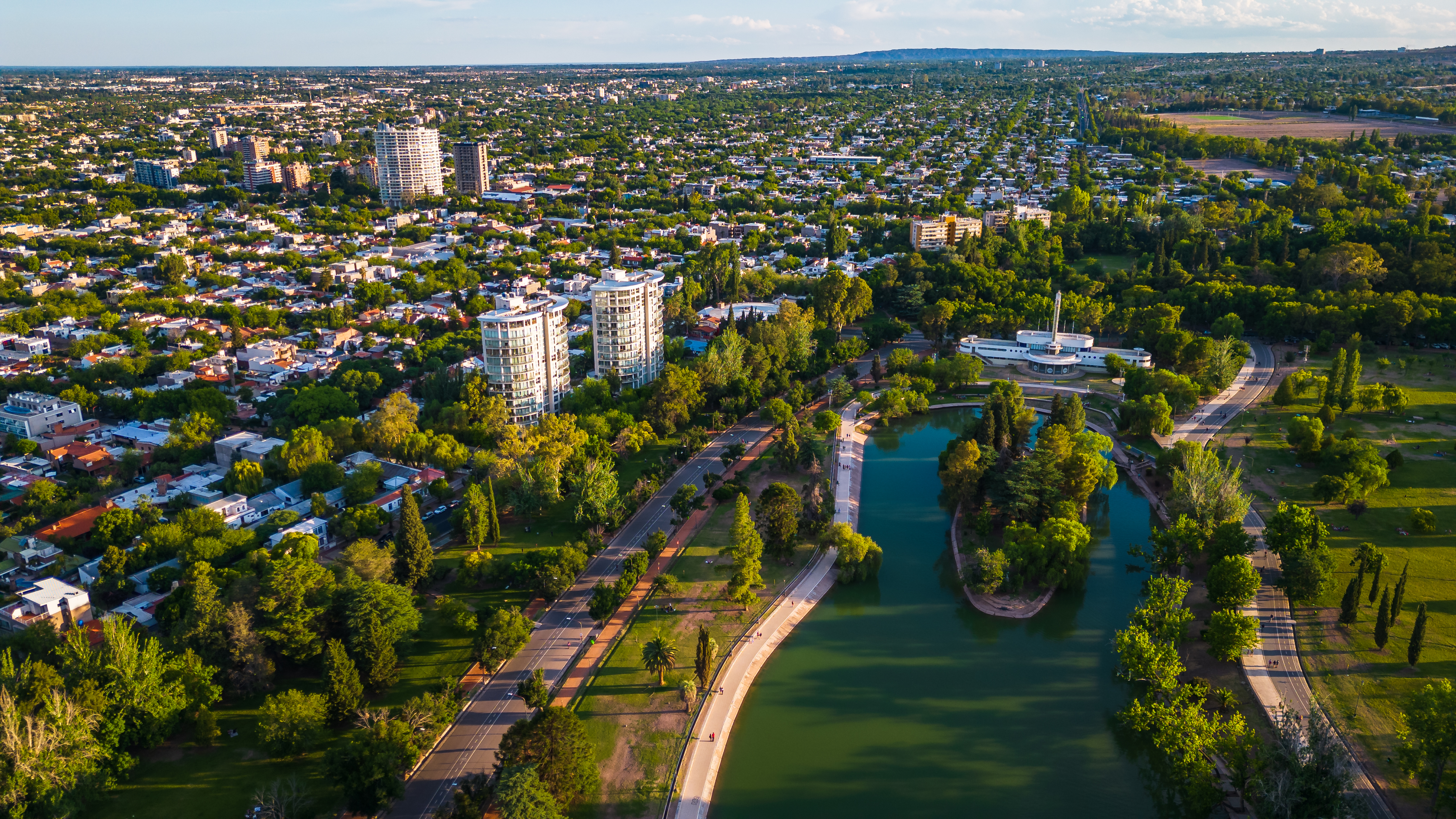 Vista aérea Parque Sarmiento, Córdoba, Argentina con lago, edificios y áreas verdes.
