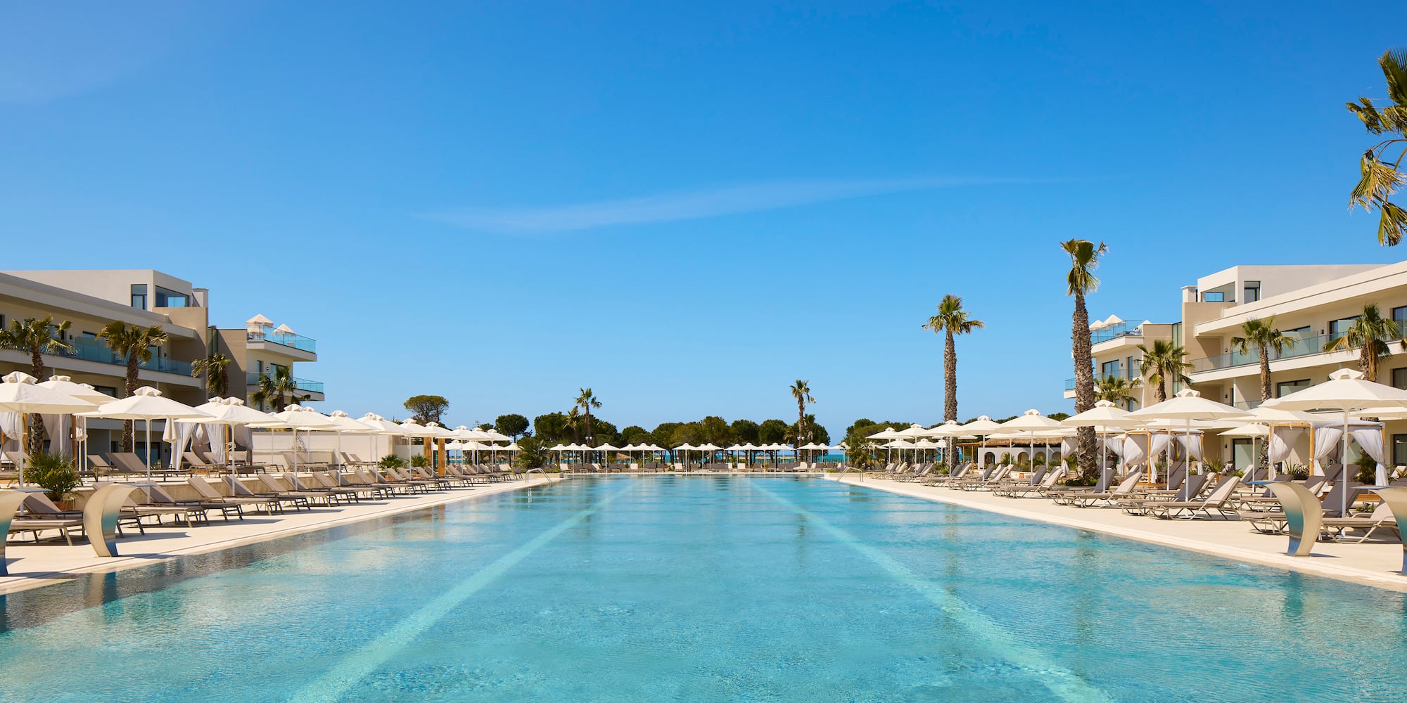 a swimming pool with lounge chairs and umbrellas