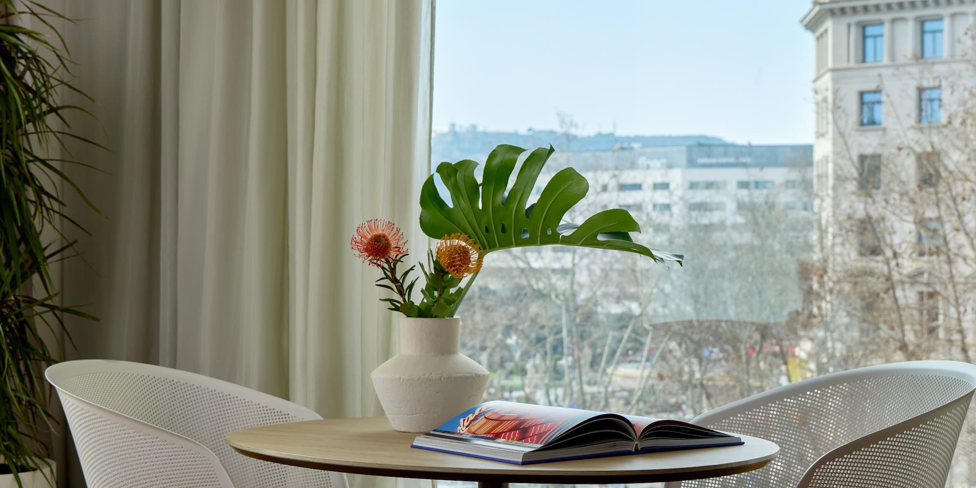 a table with chairs and a vase of flowers