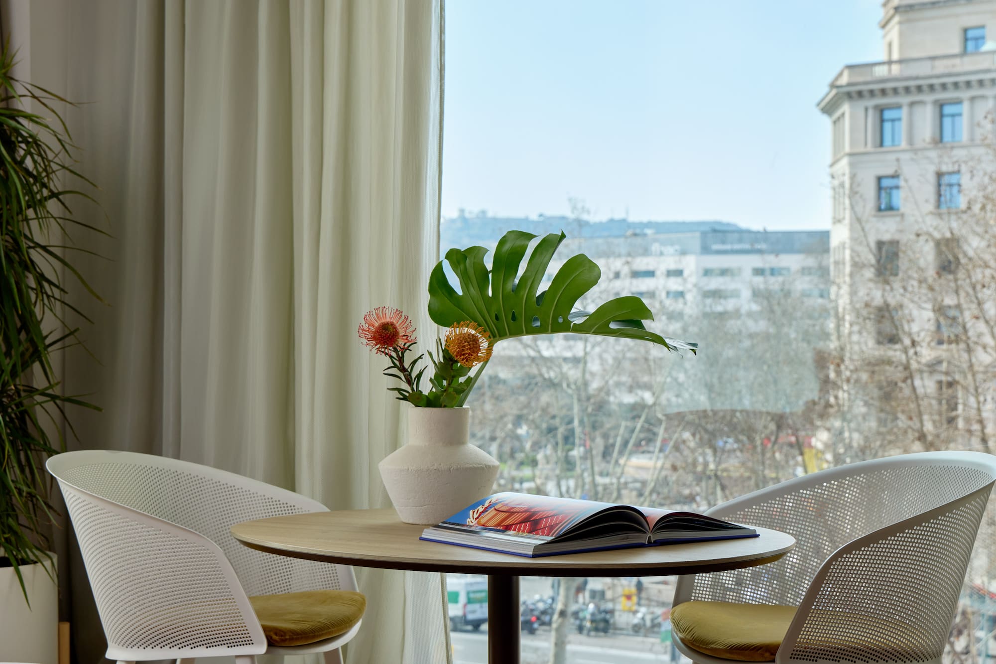 a table with chairs and a vase of flowers
