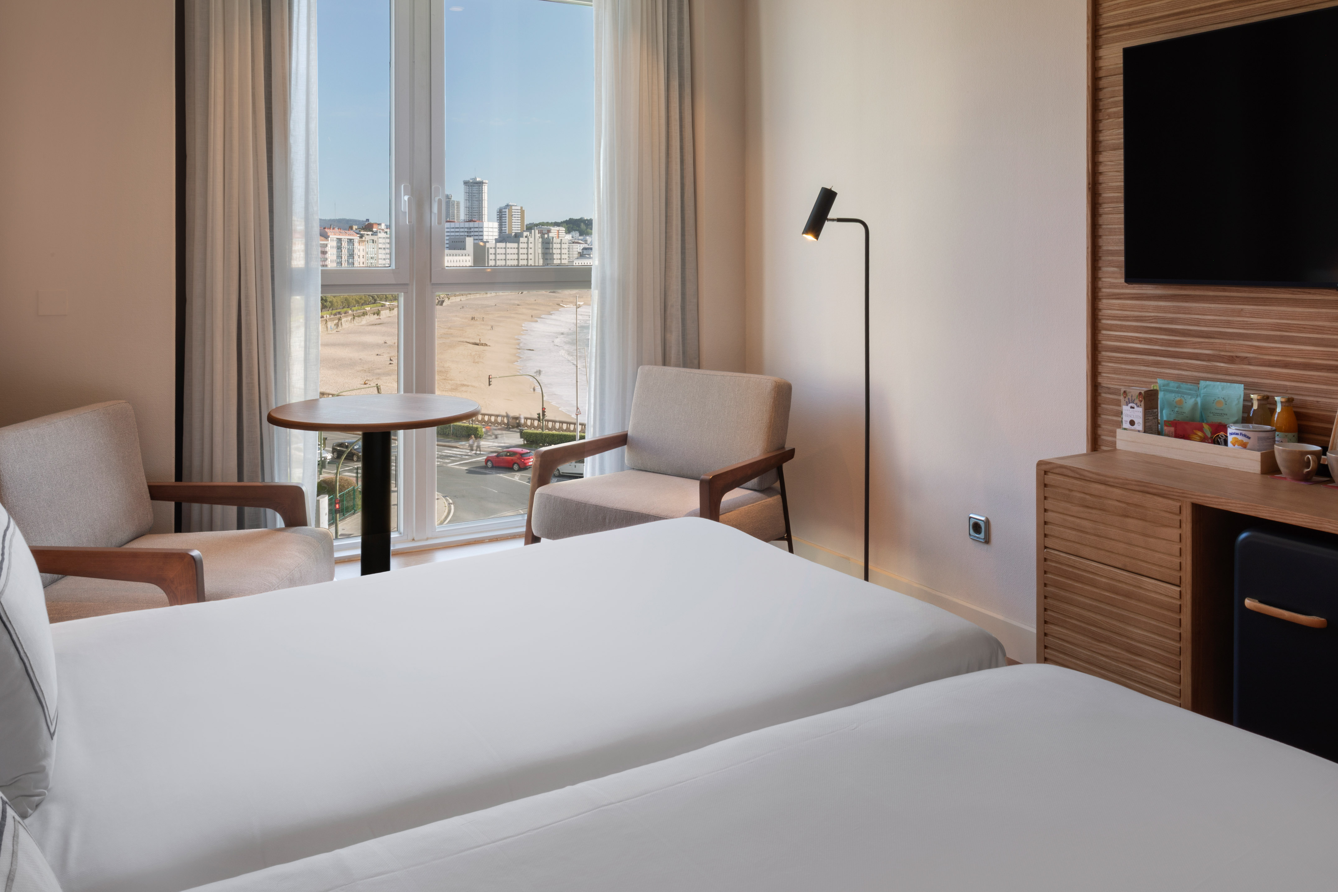 a room with two beds and a table and chairs