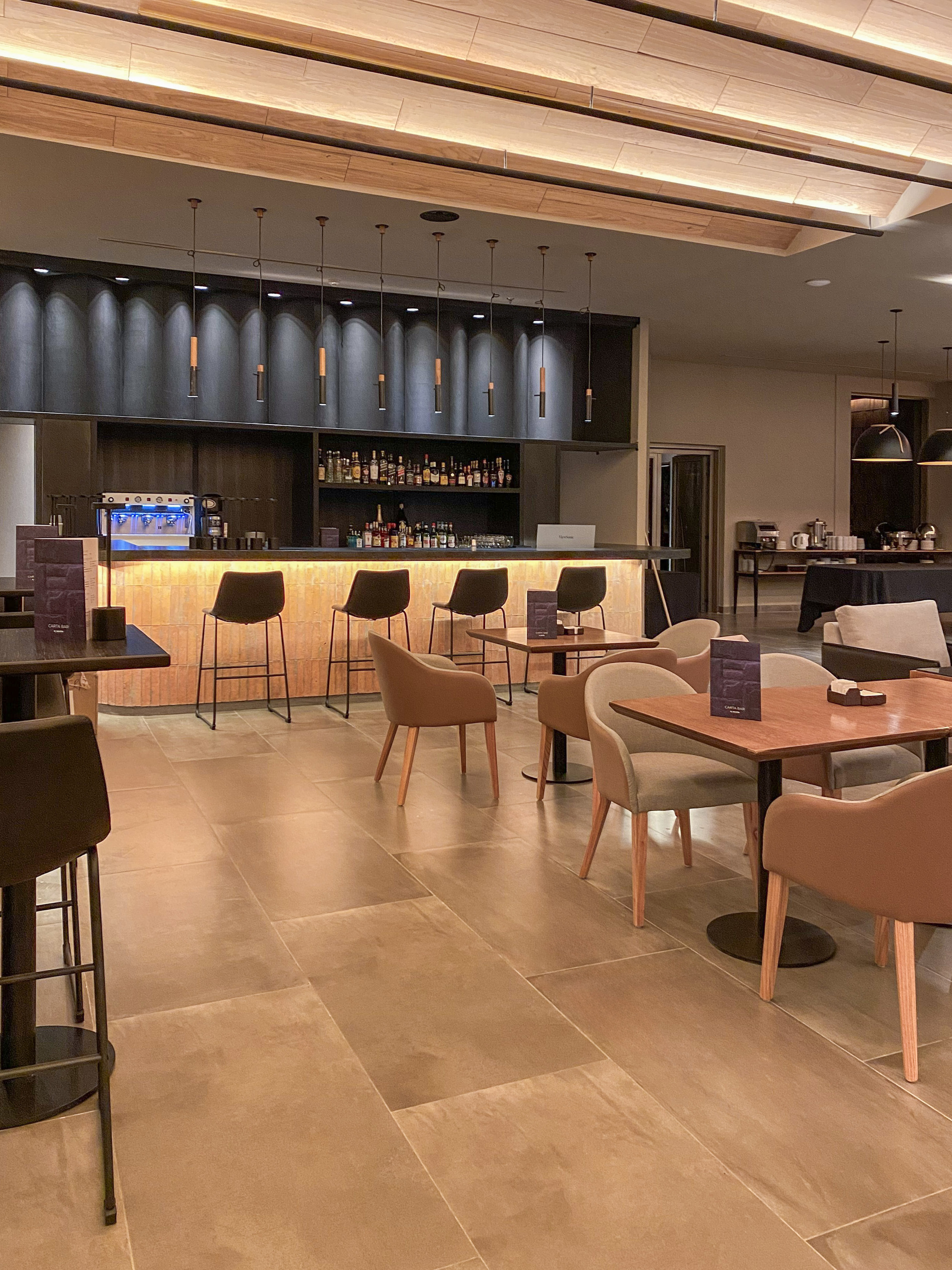 Modern hotel bar and lounge interior with comfortable seating and warm lighting.