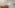 Kitchen dining area with wooden table, white cabinets, microwave, and chandelier.