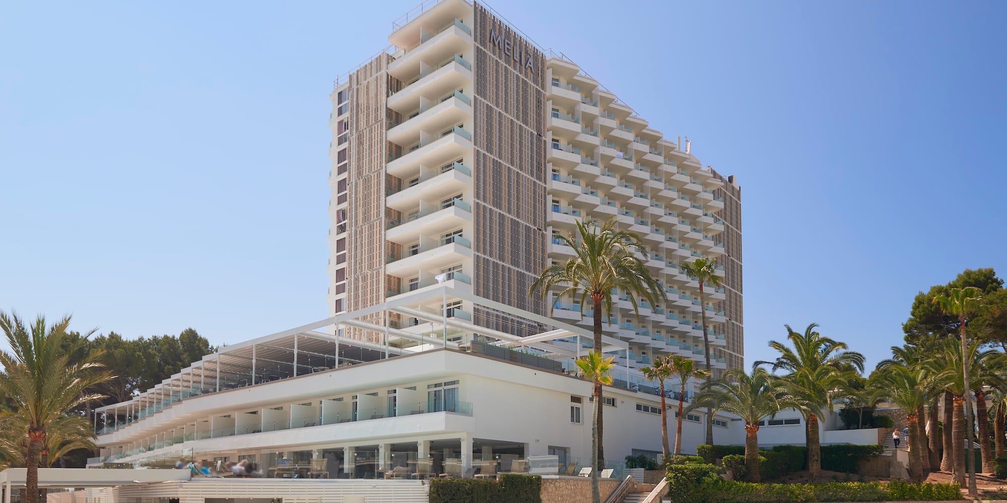 a building with a pool and palm trees