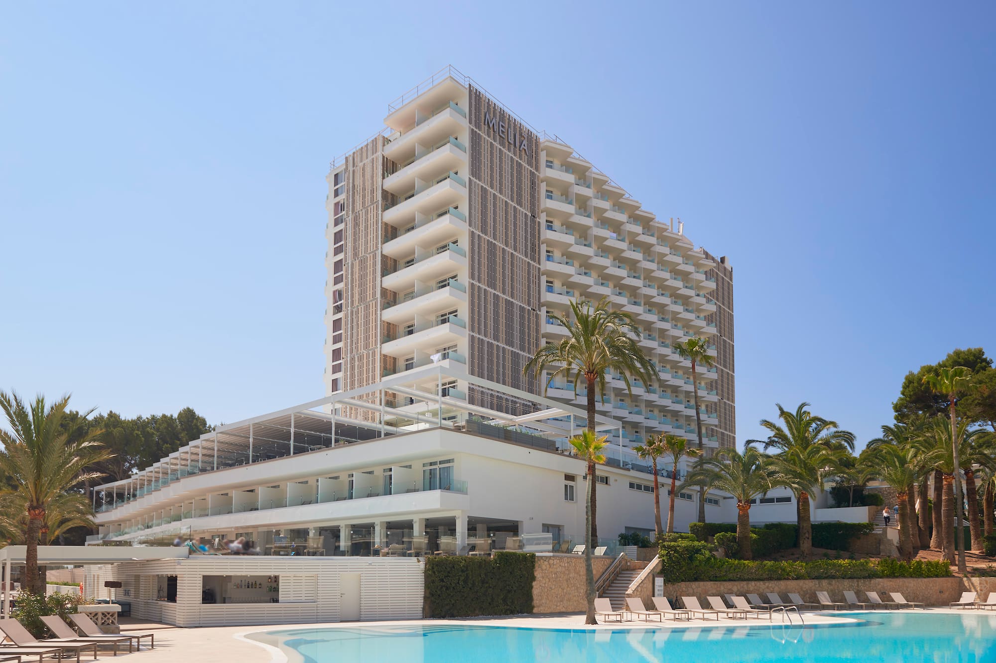 Melia resort hotel, outdoor pool, palm trees, and modern balconies.
