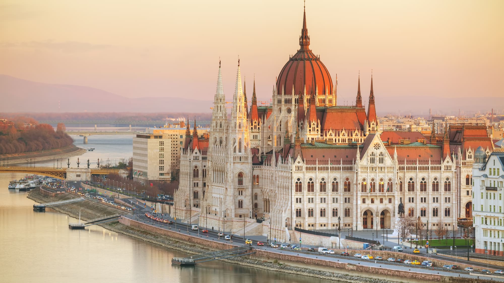 a large building with a red dome and Hungarian Parliament Building with water