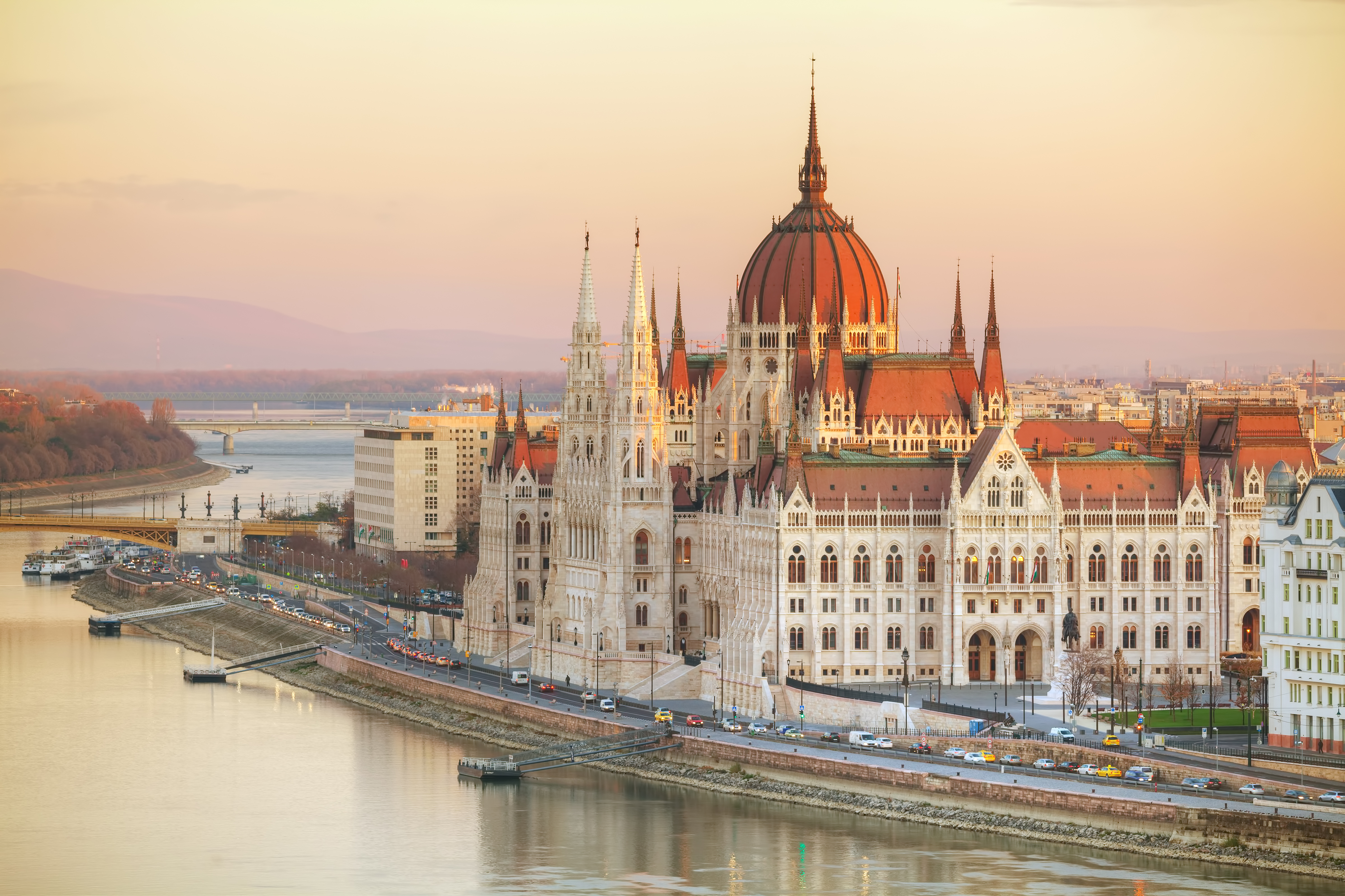 a large building with a red dome and Hungarian Parliament Building with water