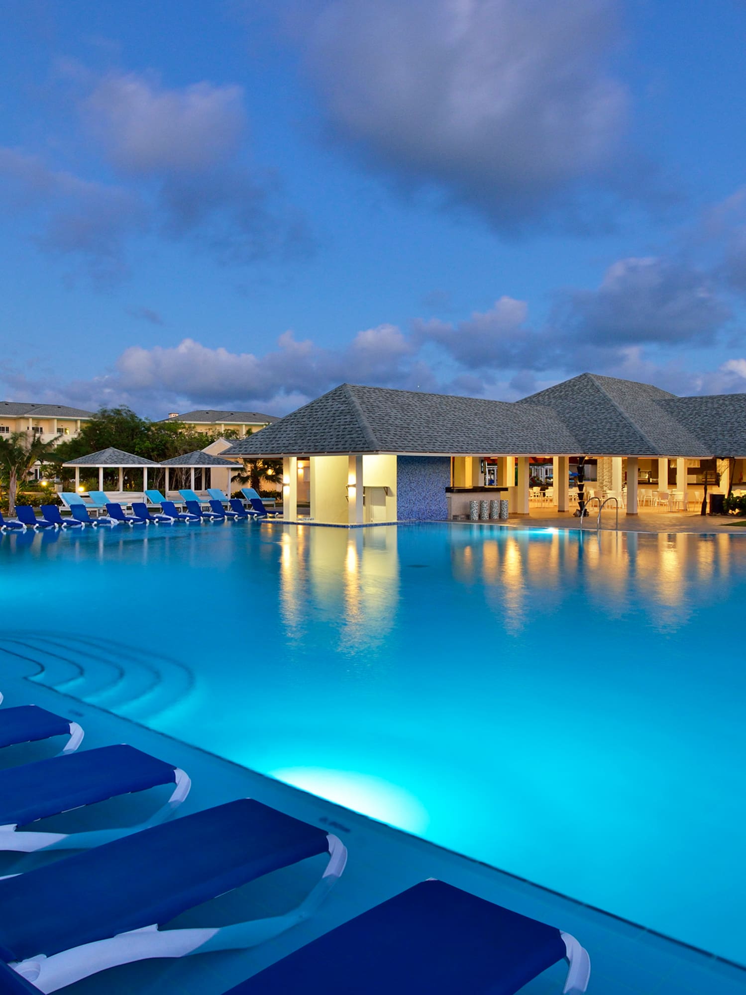 a pool with lounge chairs and a building
