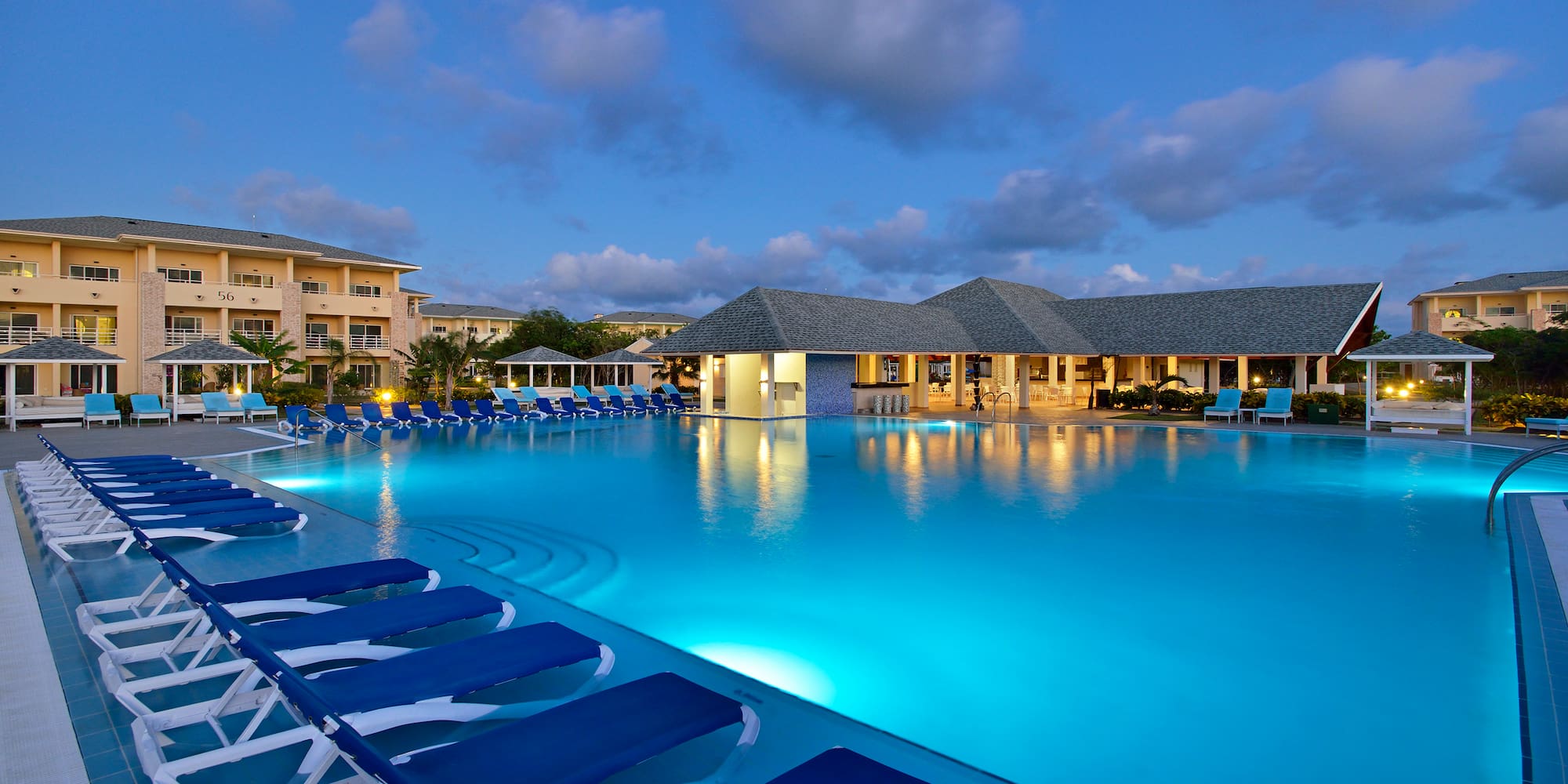 a pool with lounge chairs and a building