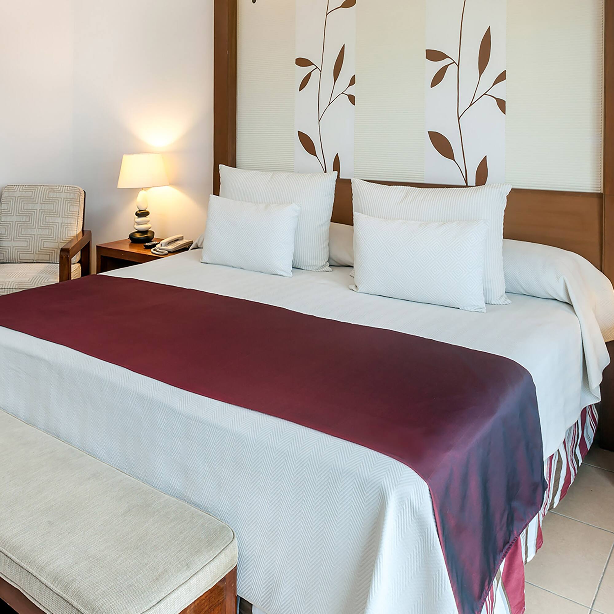 a bed with pillows and a bench in a room