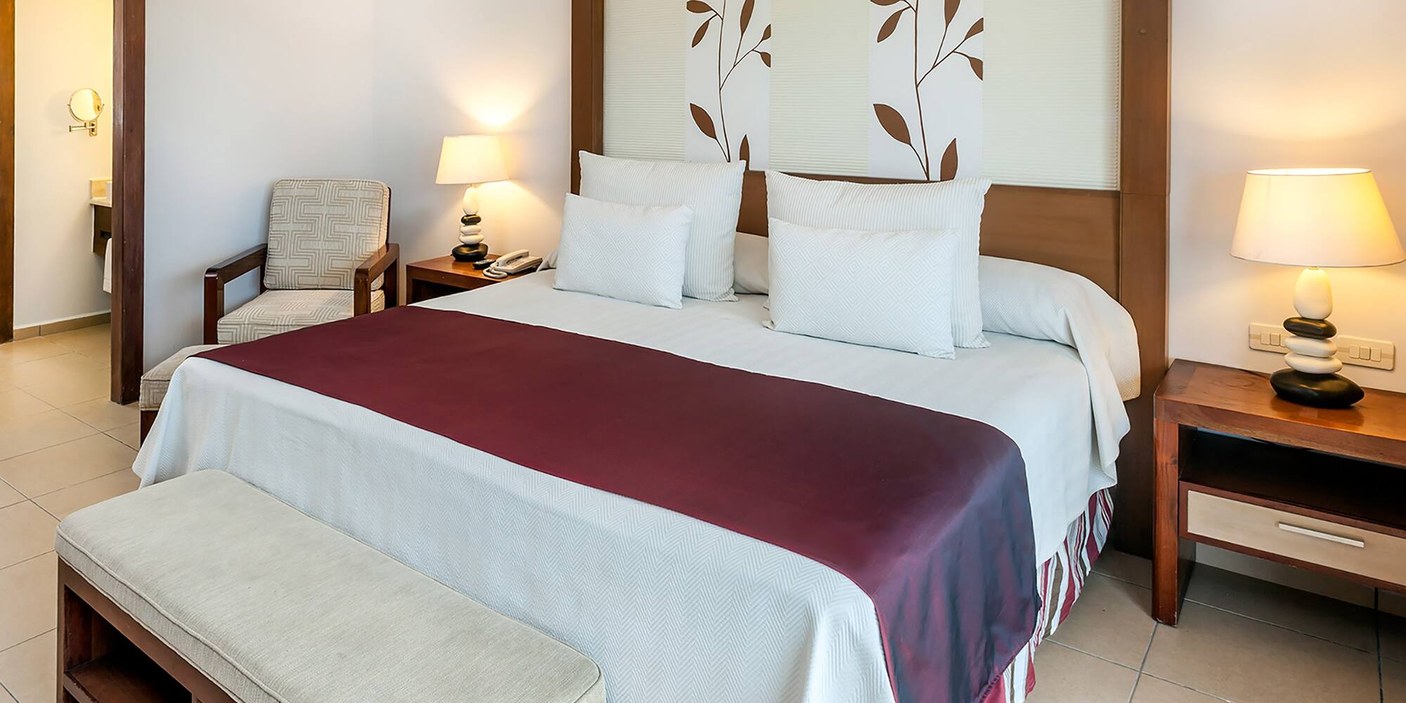 a bed with pillows and a bench in a room