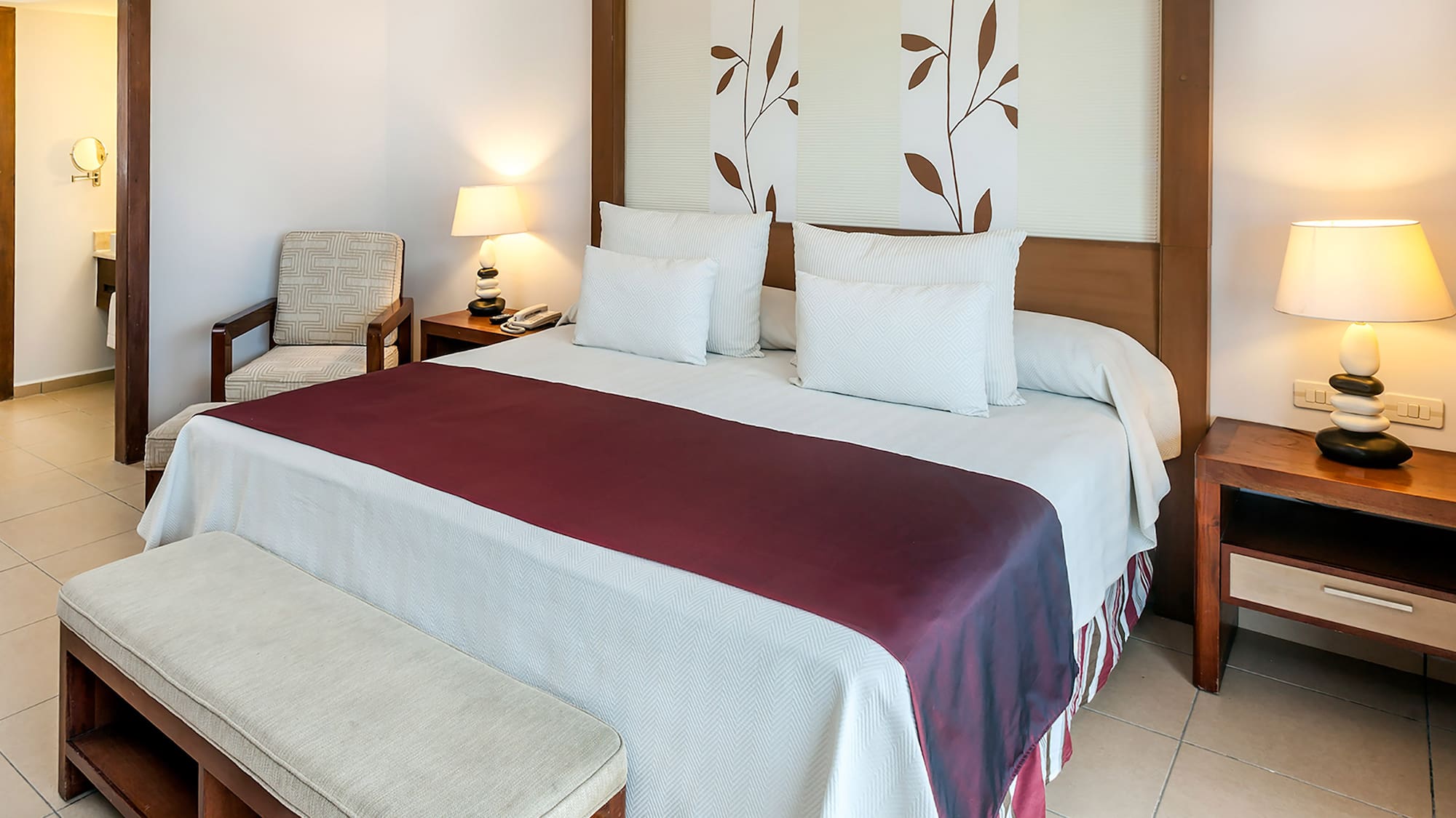 a bed with pillows and a bench in a room