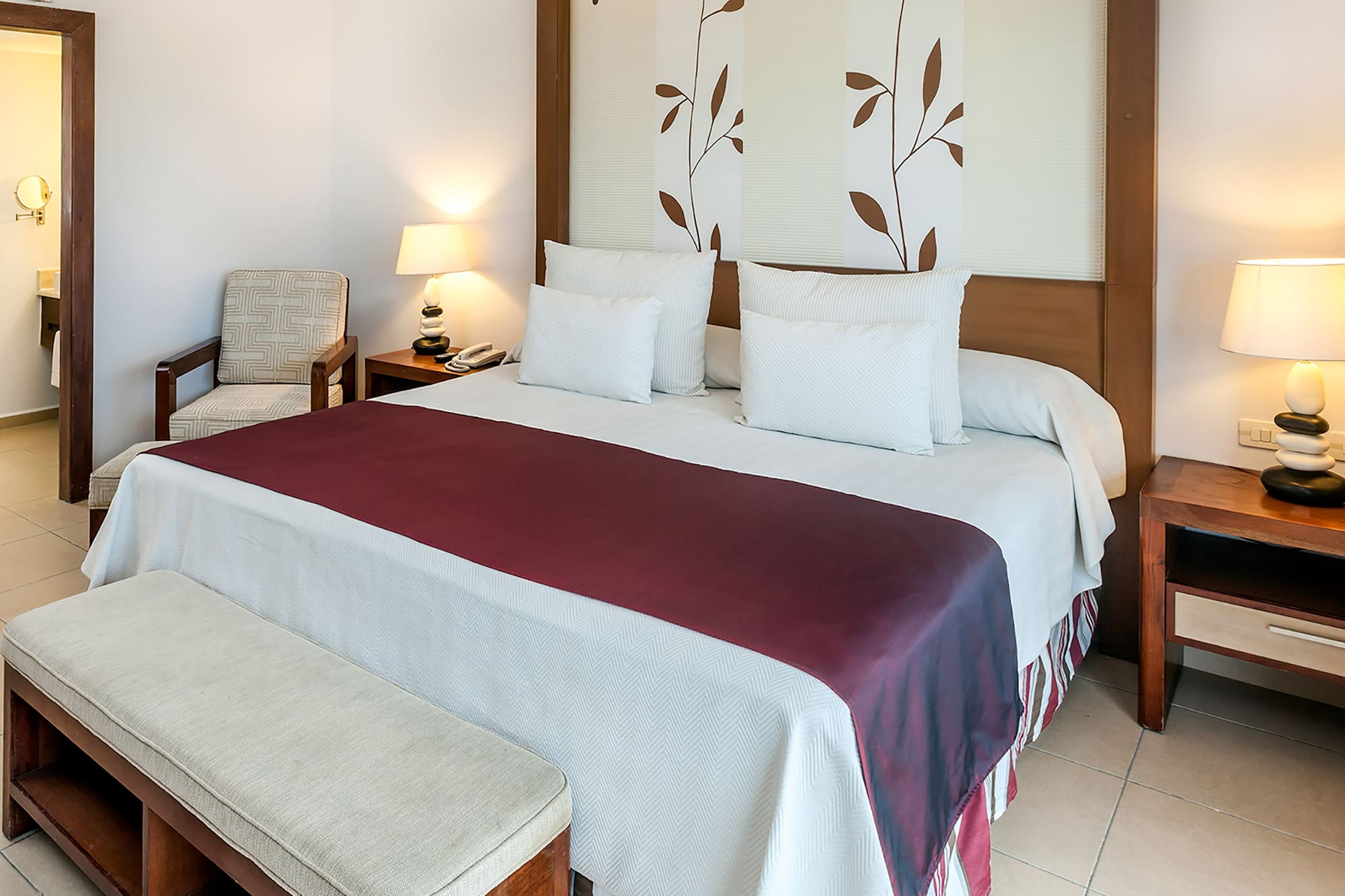 a bed with pillows and a bench in a room