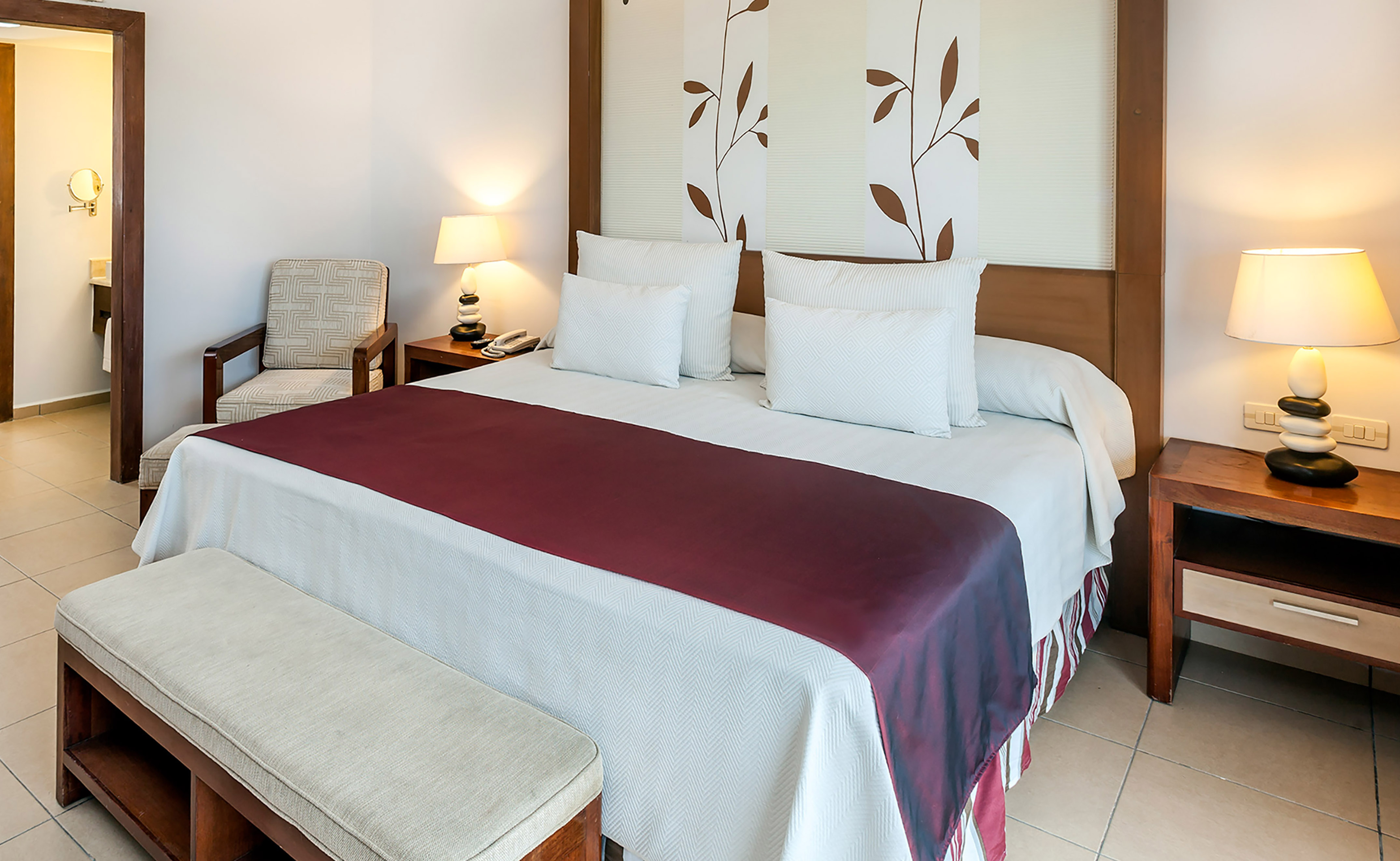 a bed with pillows and a bench in a room