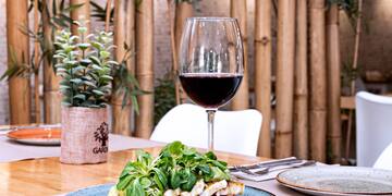 a plate of food and a glass of wine on a table