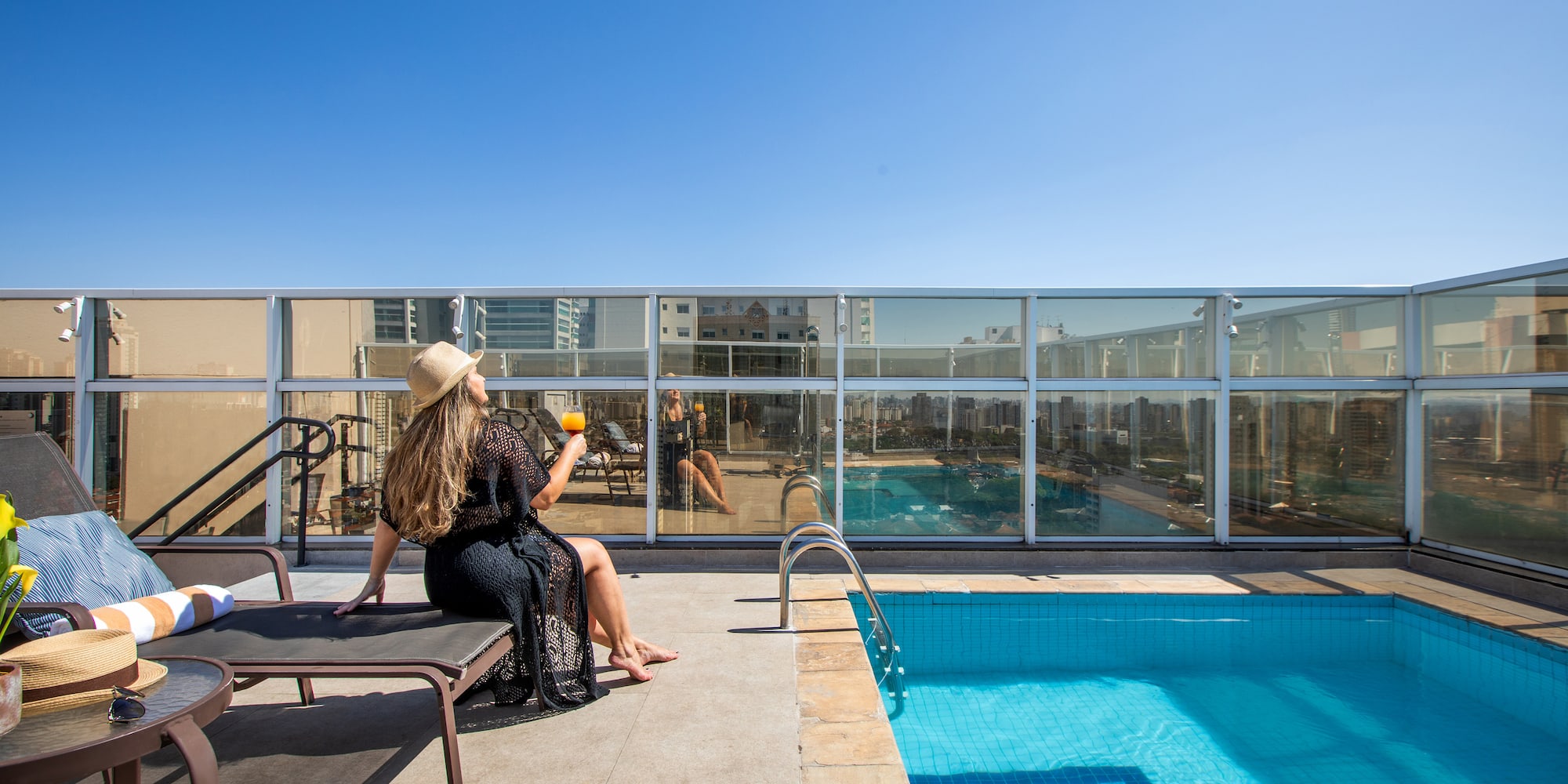 a woman sitting on a chair by a pool