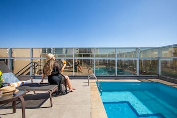 a woman sitting on a chair by a pool