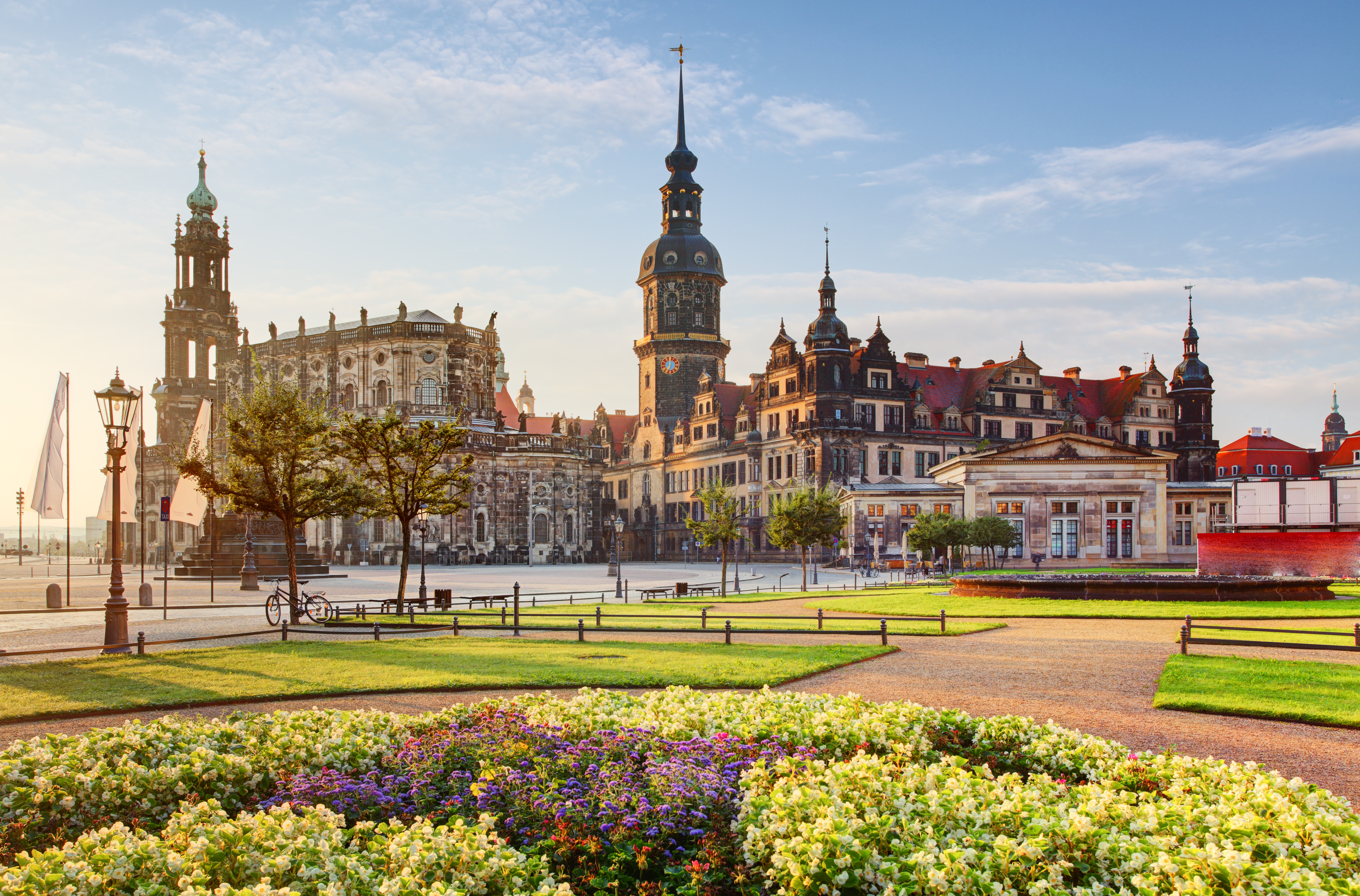 Dresden Hofkirche and Residenzschloss overlooking vibrant flower gardens.