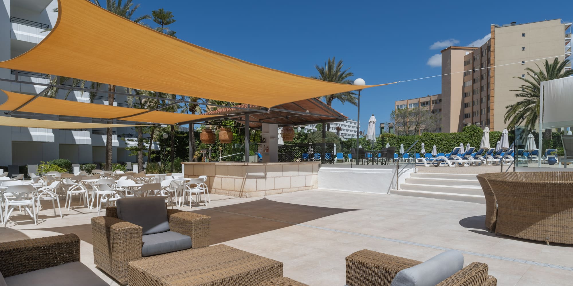 a patio with chairs and a yellow shade
