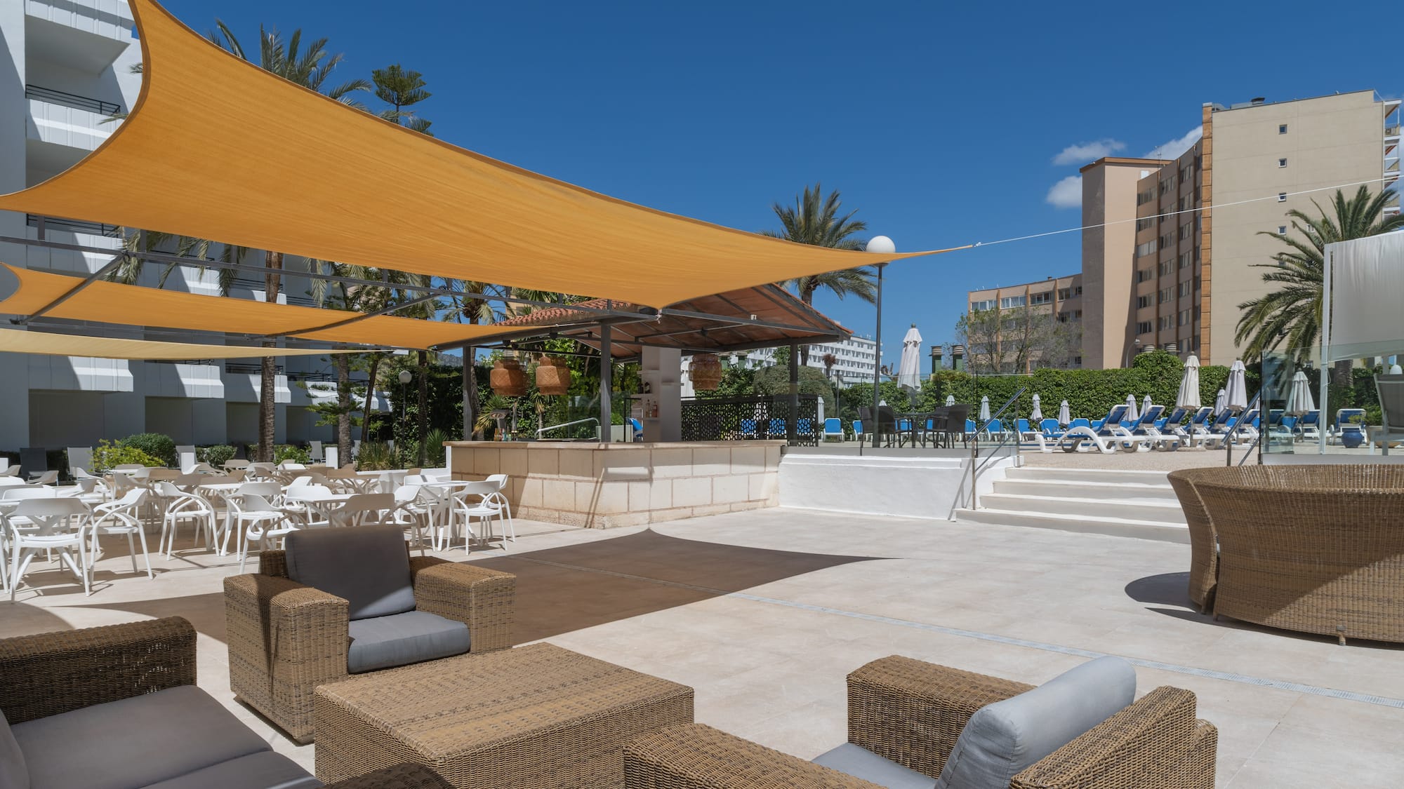 a patio with chairs and a yellow shade