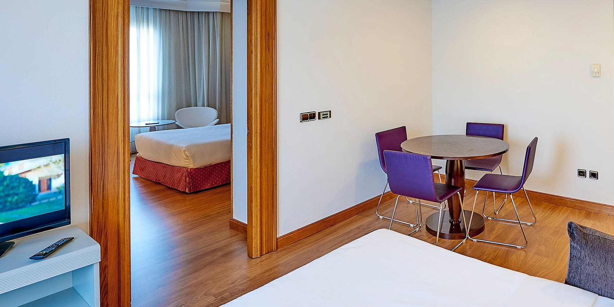 a room with a table and purple chairs