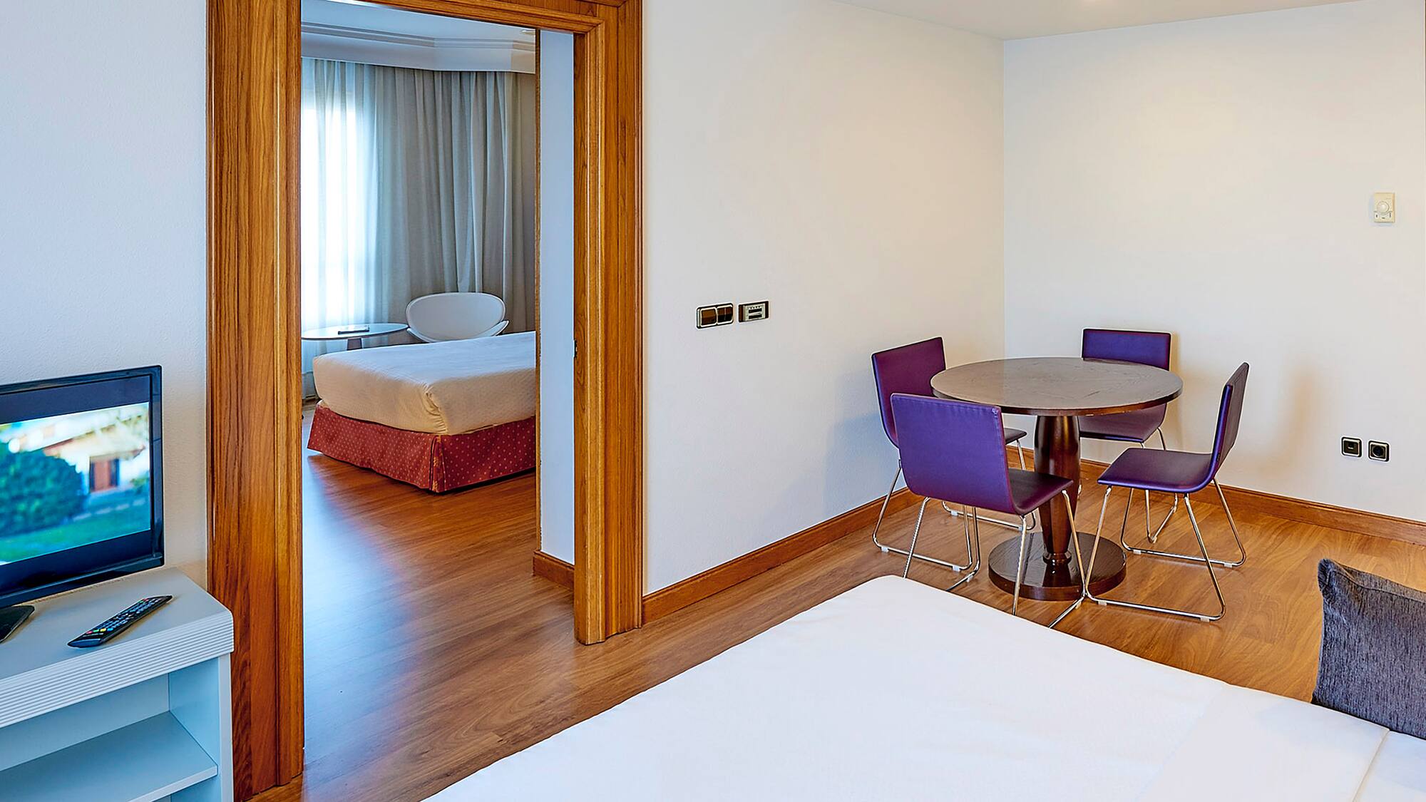 a room with a table and purple chairs