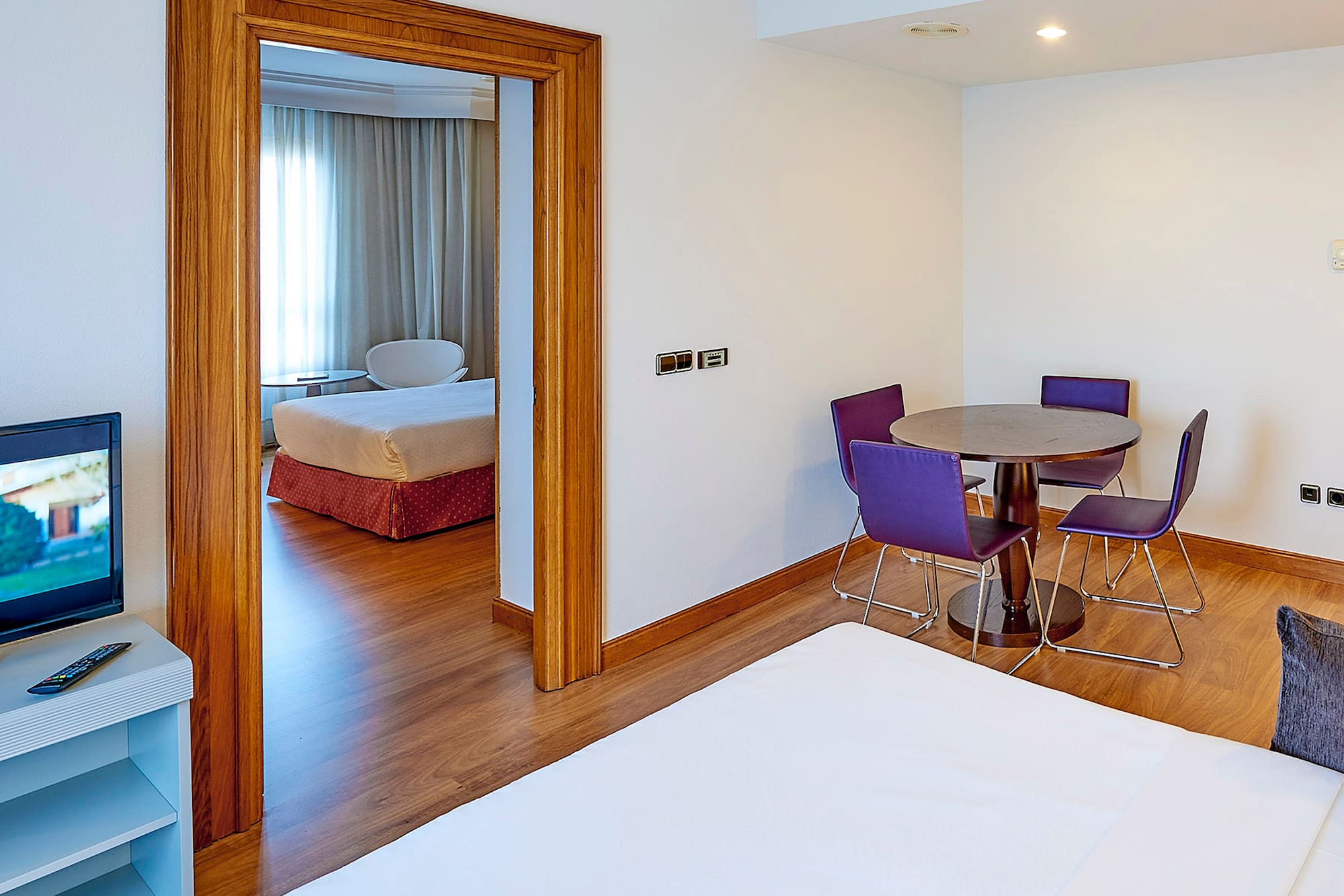 a room with a table and purple chairs