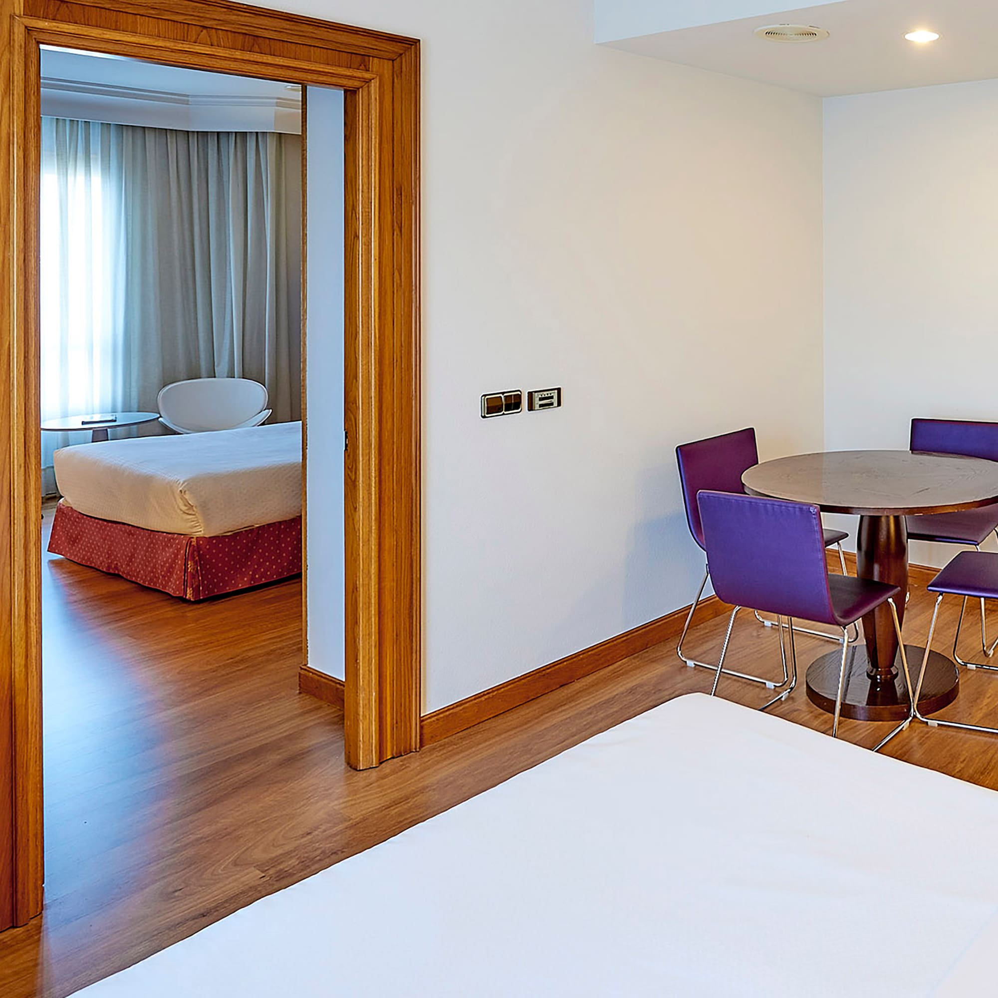 a room with a table and purple chairs